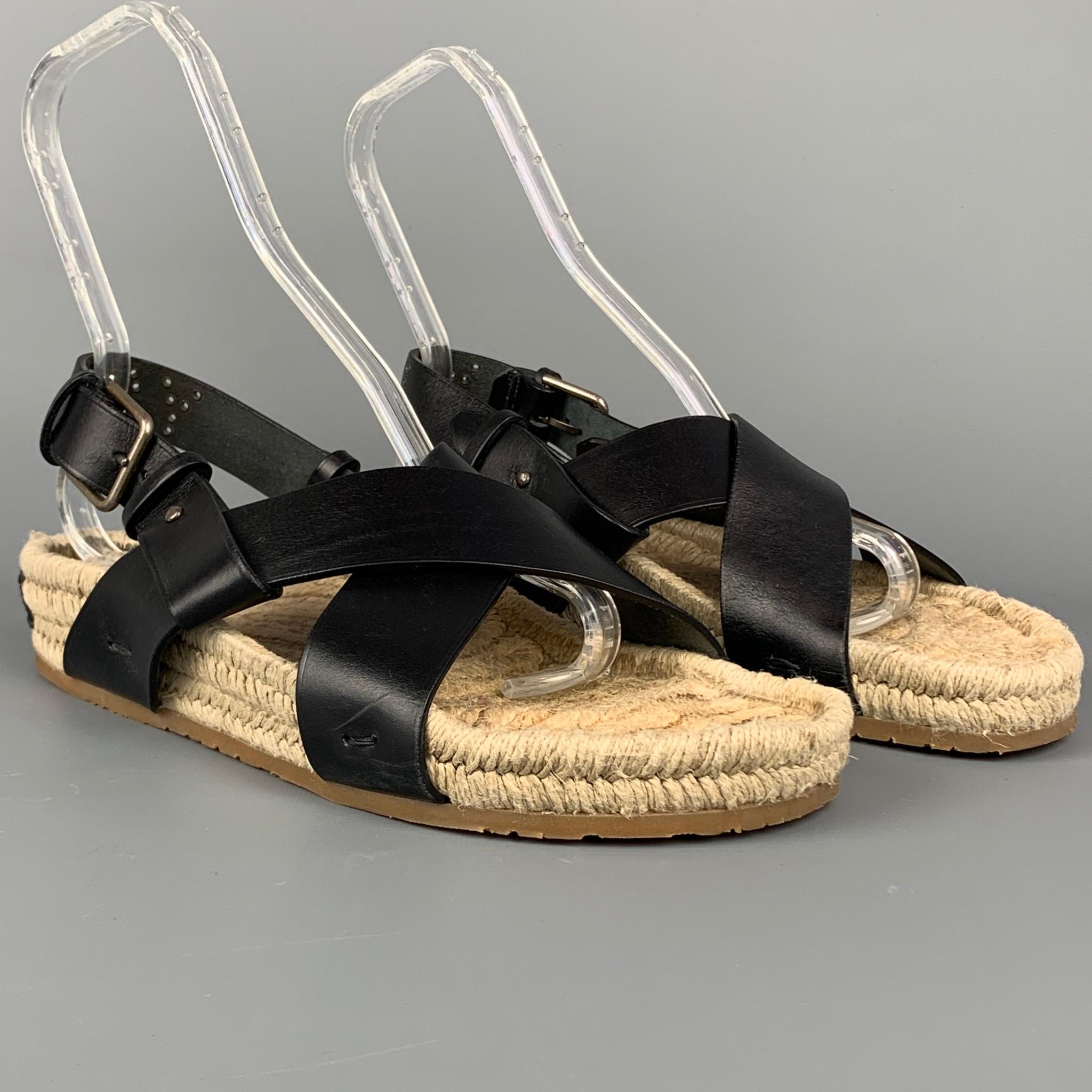 Yves Saint Laurent Rive Gauche by Tom Ford sandals comes in a black & natural leather featuring a back studded YSL rivetted design, jute sole, and a buckle strap closure. Logo on heel. Made in Italy. 

Very Good Pre-Owned Condition.
Marked: