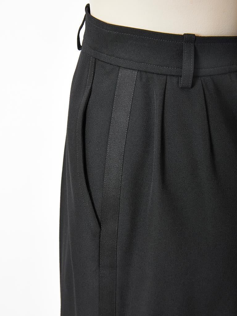 Yves Saint Laurent, black wool, gaberdine, cuffed, Bermuda short, having a men's style fly front, with hip pleats and belt loops. Satin, tuxedo stripe goes down each side.