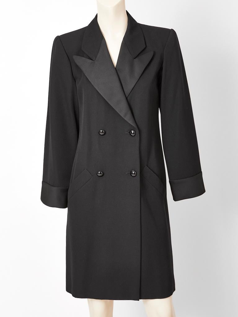 Yves Saint Laurent, Rive Gauche, wool gaberdine, double breasted, tuxedo coat dress have a satin notched collar and self belt. 