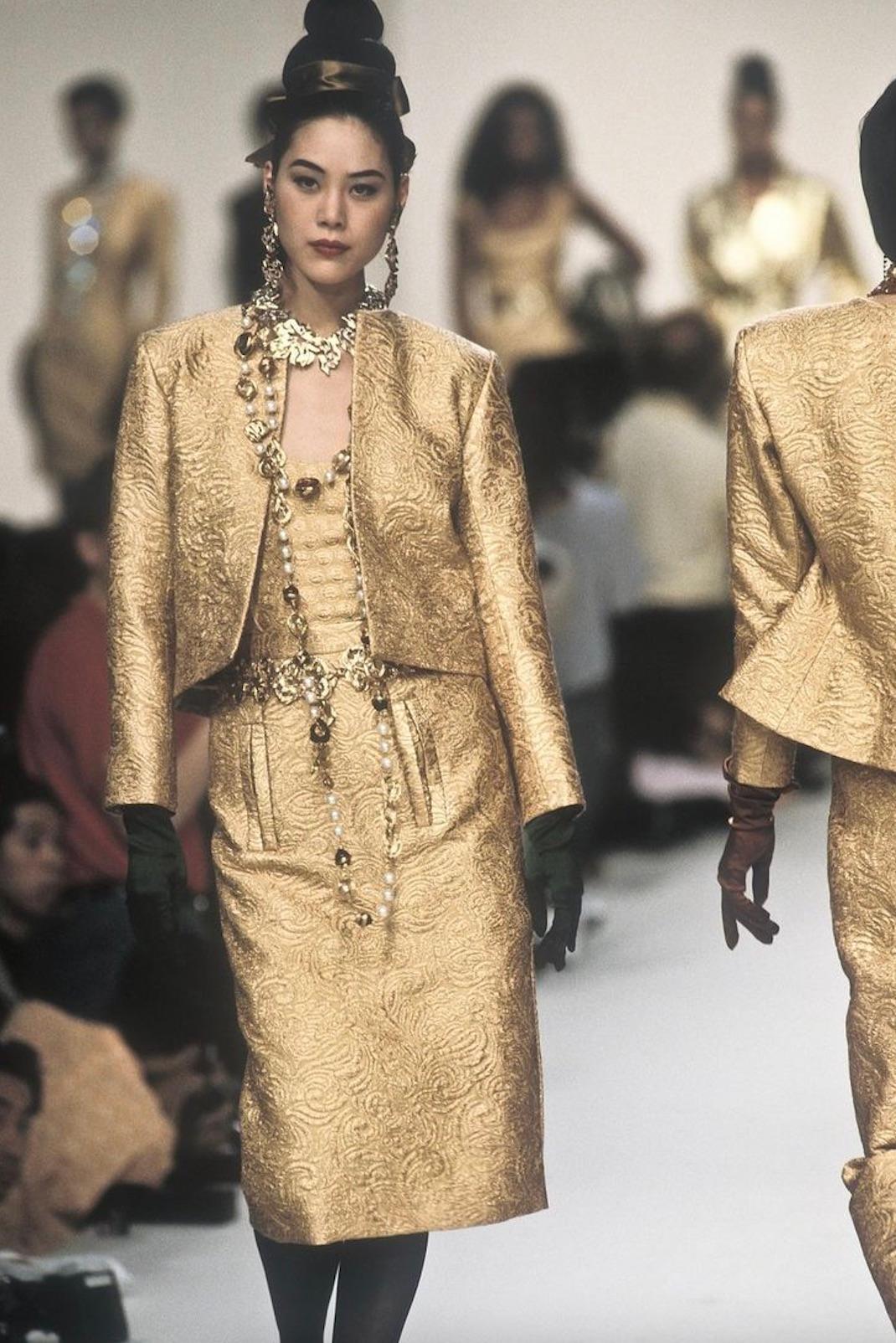 Dieses auffällige zweiteilige Ensemble besteht aus einer wunderschön geschneiderten Jacke und einem passenden Bleistiftrock mit hoher Taille, die beide aus einem reich strukturierten, vom Barock inspirierten Brokat in leuchtendem Goldmetallic