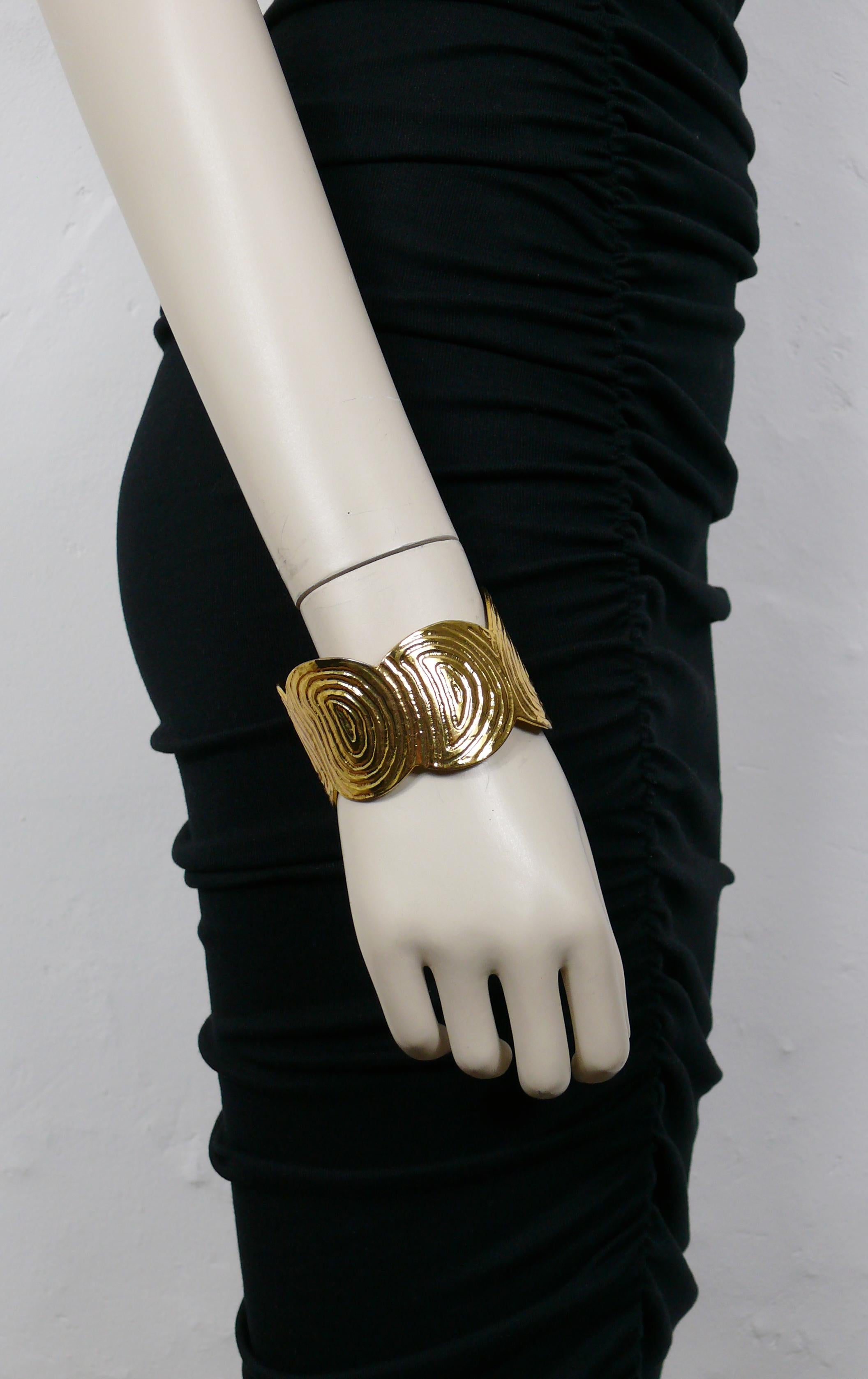 YVES SAINT LAURENT RIVE GAUCHE vintage gold toned cuff bracelet featuring a fingerprint design.

Embossed YVES SAINT LAURENT RIVE GAUCHE Made in France.

Indicative measurements : inner circumference approx. 20.42 cm (8.04 inches) / max. width