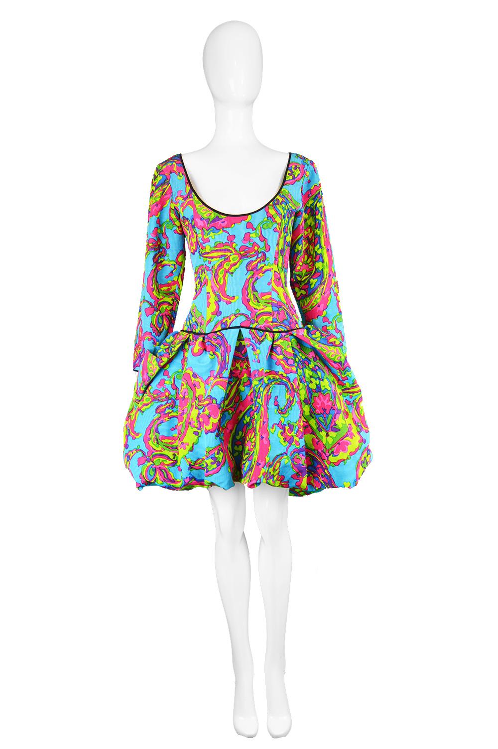 A showstopping vintage dress from the late 80s by legendary French fashion designer, Yves Saint Laurent. In a boldly multicolored, watered silk taffeta / moiré fabric with a paisley inspired pattern throughout in hues of blue, pink, purple and