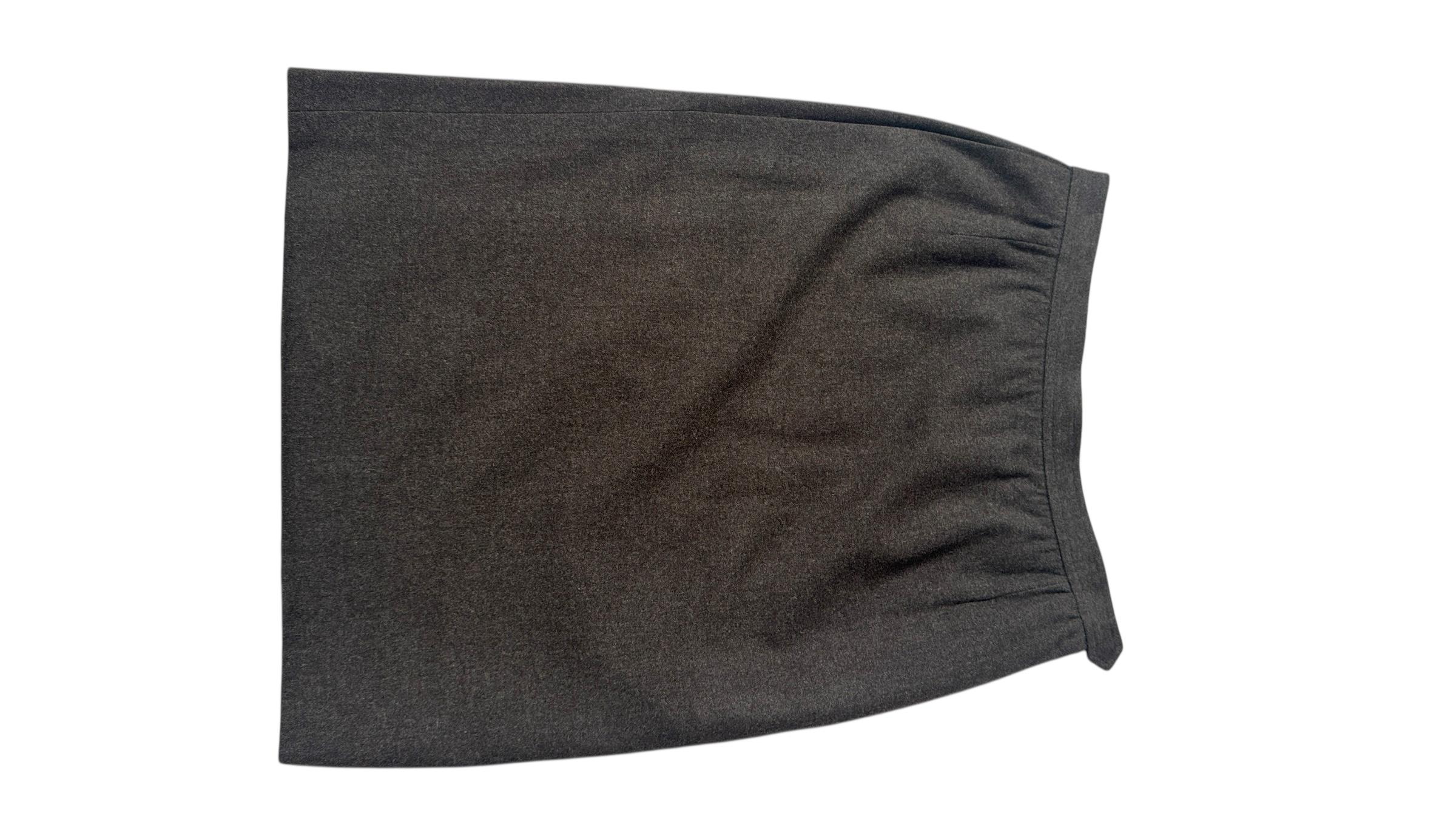 An elegant and timeless vintage piece from Yves Saint Laurent’s iconic Rive Gauche line. Crafted in France during the 1980s, this classic high-waisted skirt is tailored in a rich dark grey wool and fully lined in olive green acetate, ensuring