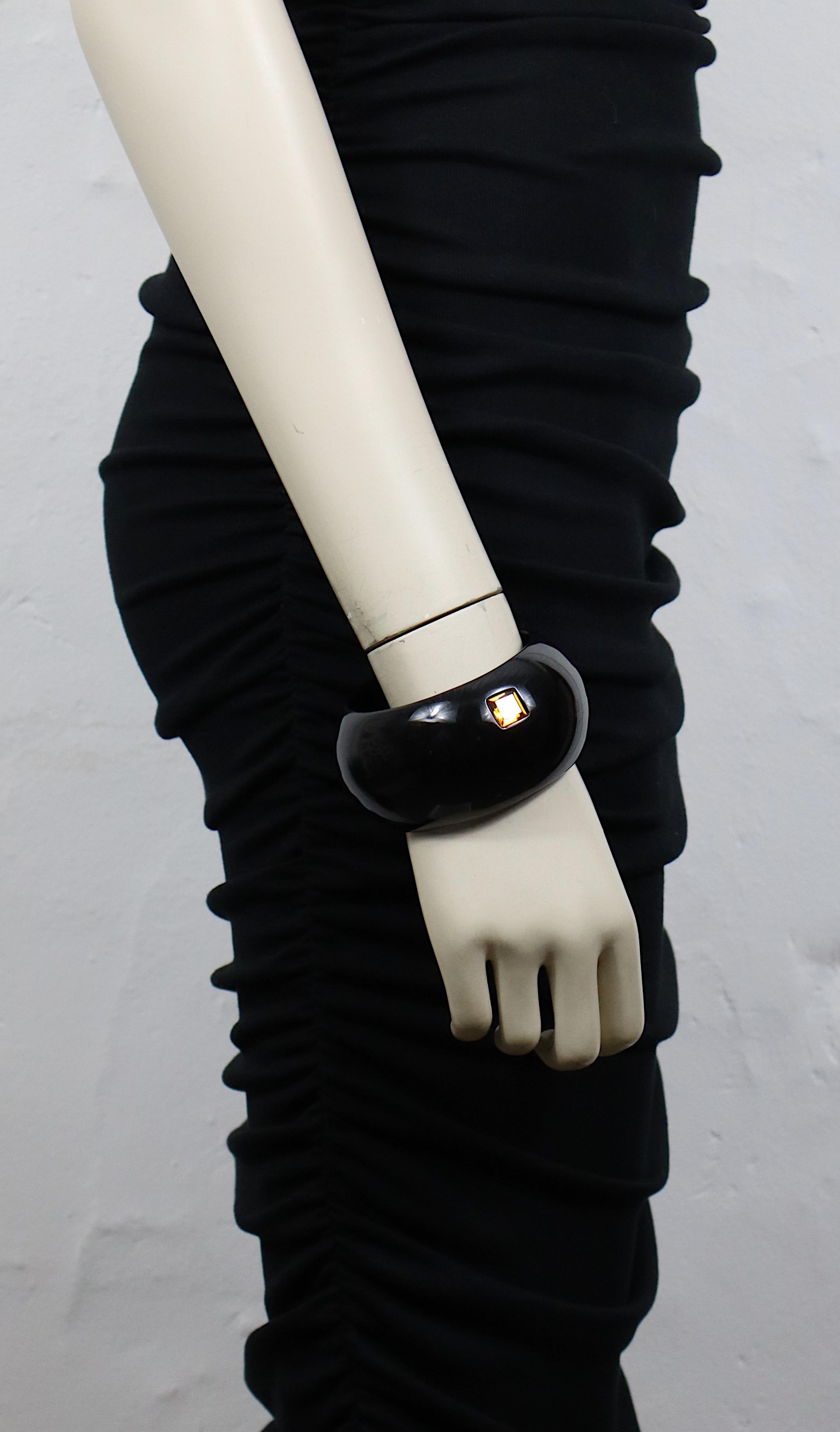 Bracciale in resina nera di Yves Saint Laurent con un cristallo color citrino.

Yves Saint Laurent Rive Gauche Made in France.

Misure indicative: circonferenza interna circa 20,42 cm (8,04 pollici) / larghezza circa 4,2 cm (1,65
