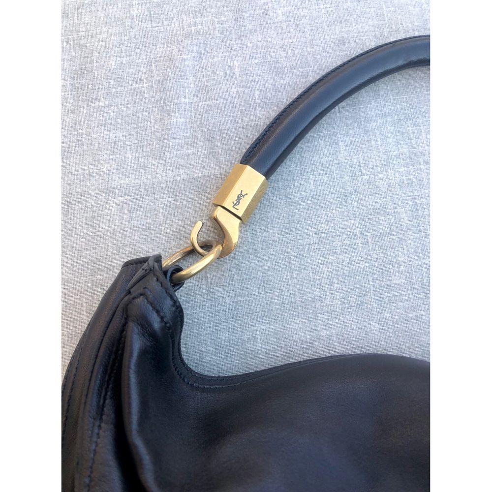 Yves Saint Laurent Roady Leather Handbag in Black

Yves Saint Laurent Roady model bag in very soft black leather with gold hardware. Magnetic button closure and roomy interior with pochettina. It has some signs of use on the leather, as can be seen