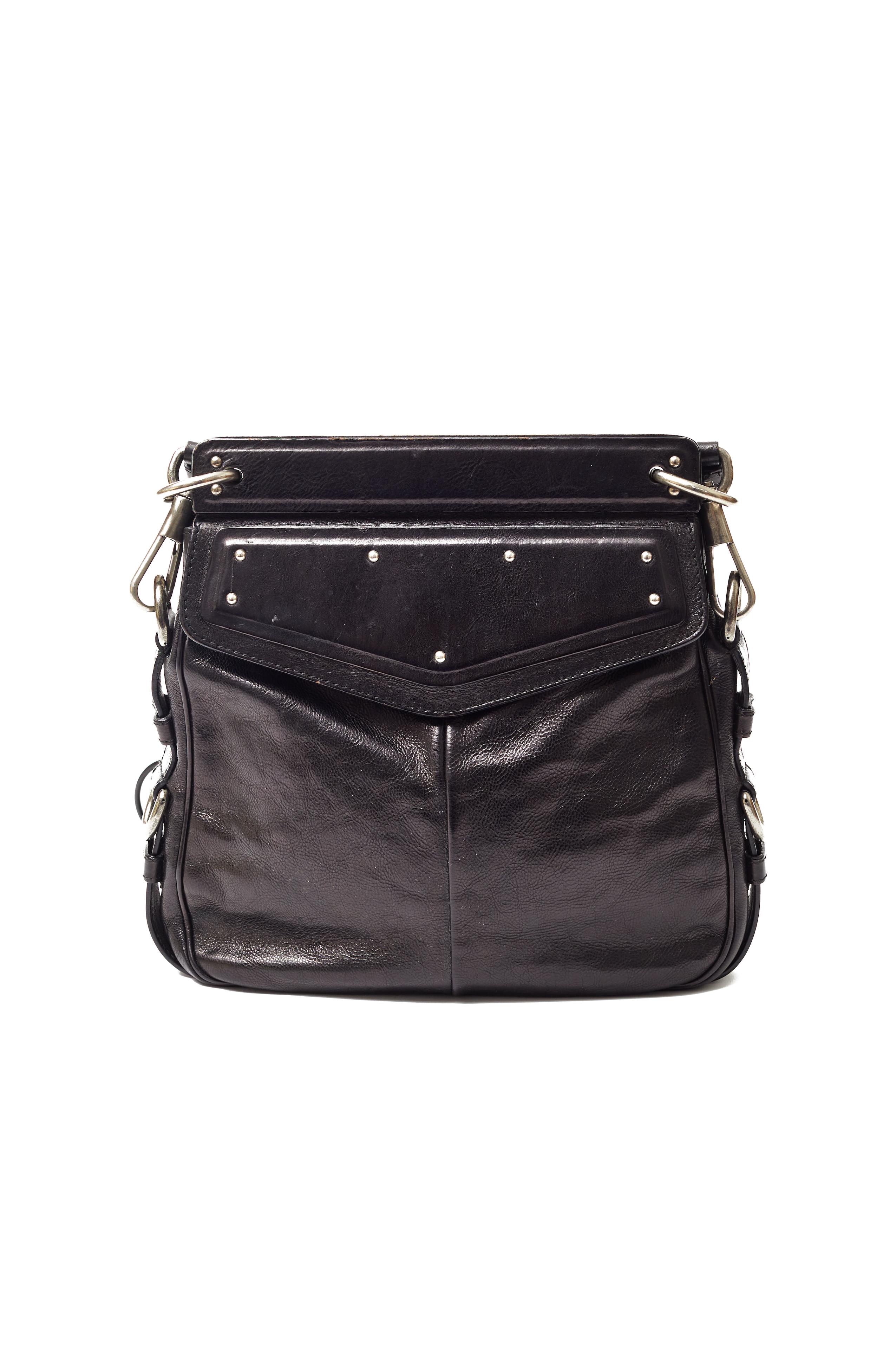 Dating to the S/S 2002 collection designed by Tom Ford, this Mombassa bag by Yves Saint Laurent is made from distressed black leather with silver studding and a silver embellished horn handle. Fully lined in black suede, this closes with a magnetic