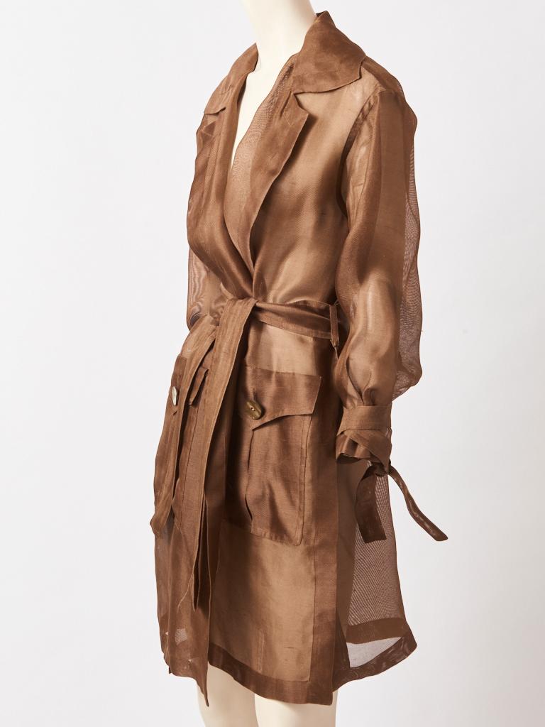 Yves Saint Laurent, Rive Gauche, mocha tone, silk Gazar, belted trench/coat. The trench is sheer and diaphanous, having wide lapels and two large deep flap pocket detail and a self belt.