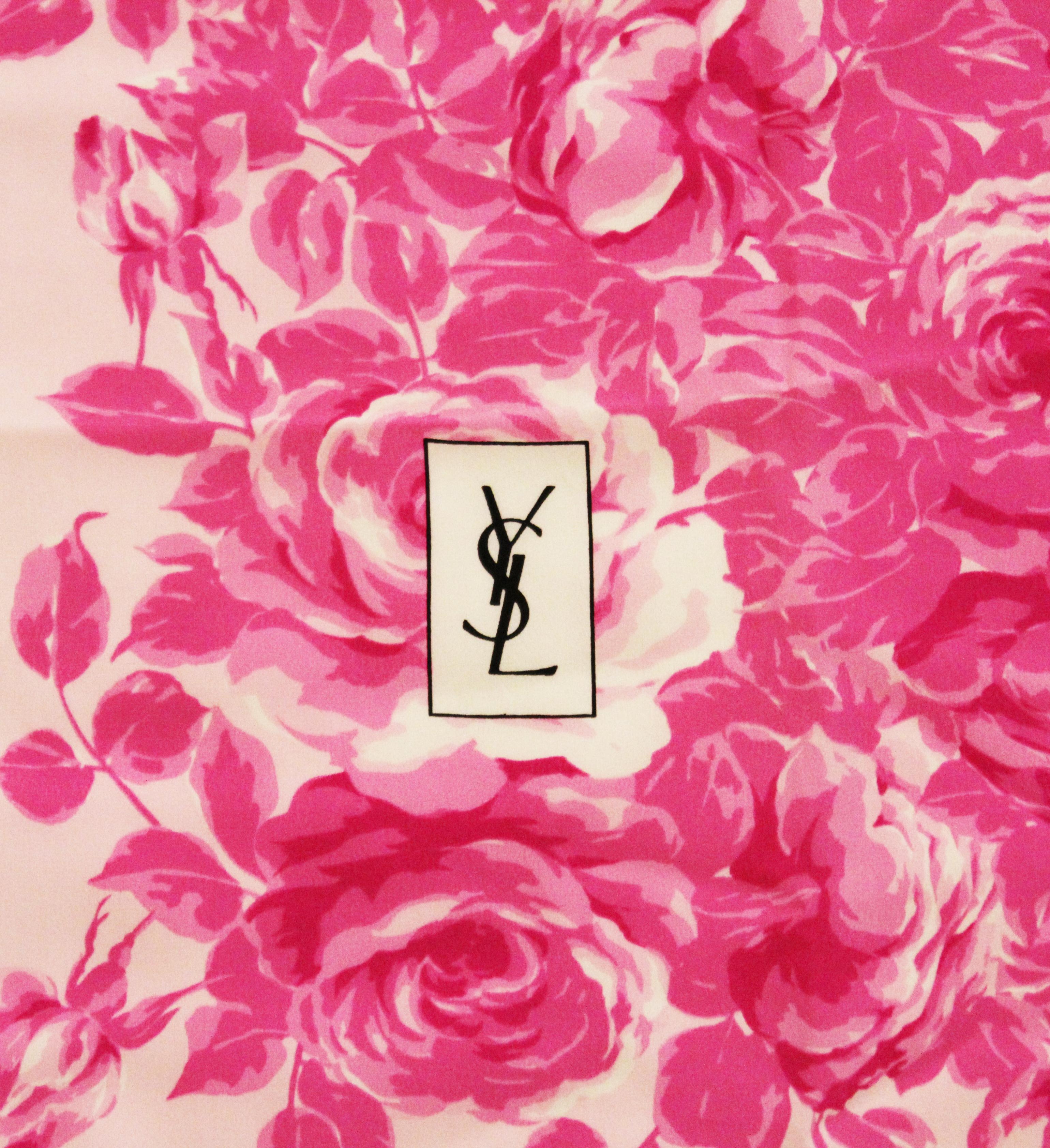 Yves Saint Laurent silk pink on pink rose scarf is brilliantly vibrant with the pale pink background and hot pink roses.  This lovely scarf has the YSL logo integrated into the scarf in black lettering.  This scarf in silk crepe de chine with hand