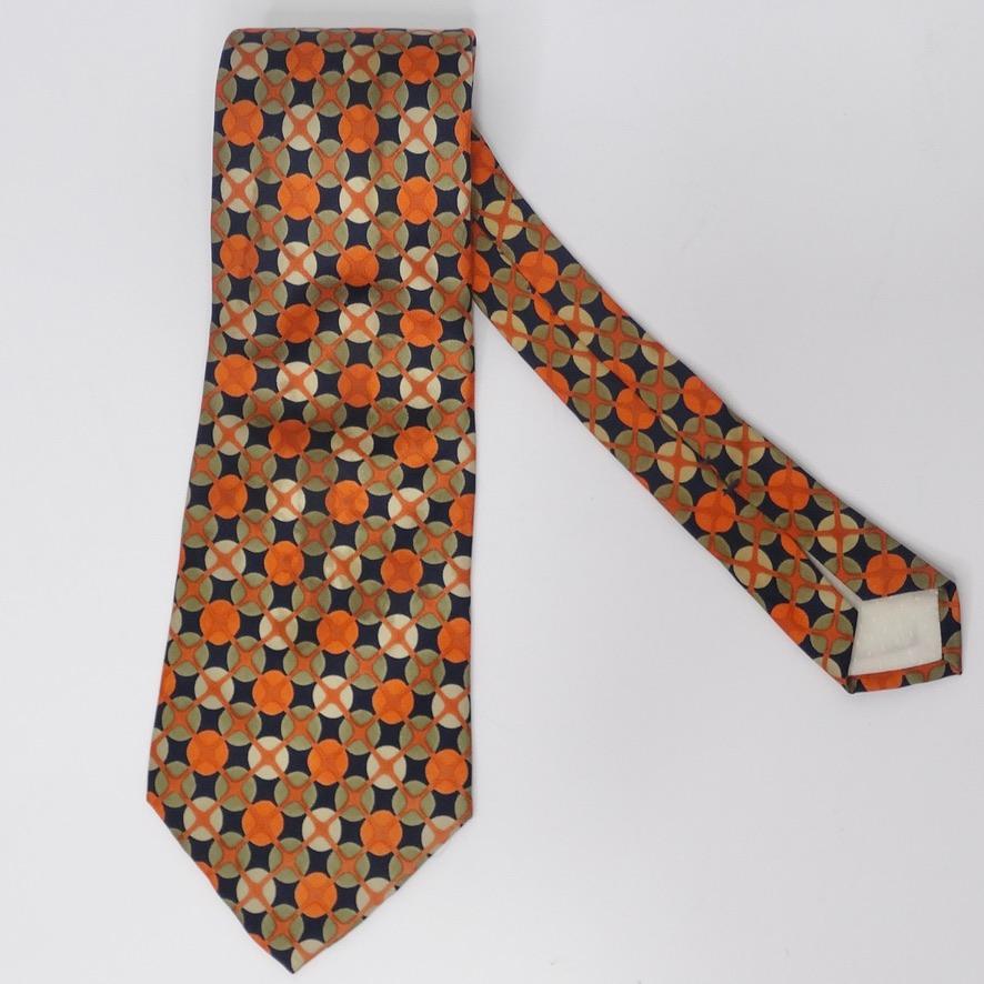 Vintage Yves Saint Laurent 100% silk tie in a gorgeous geometric pattern. The warm toned neutrals of the color palette make for versatility with wear while still allowing for a subtle pop of color with the vibrant orange. Wear this over a Prada
