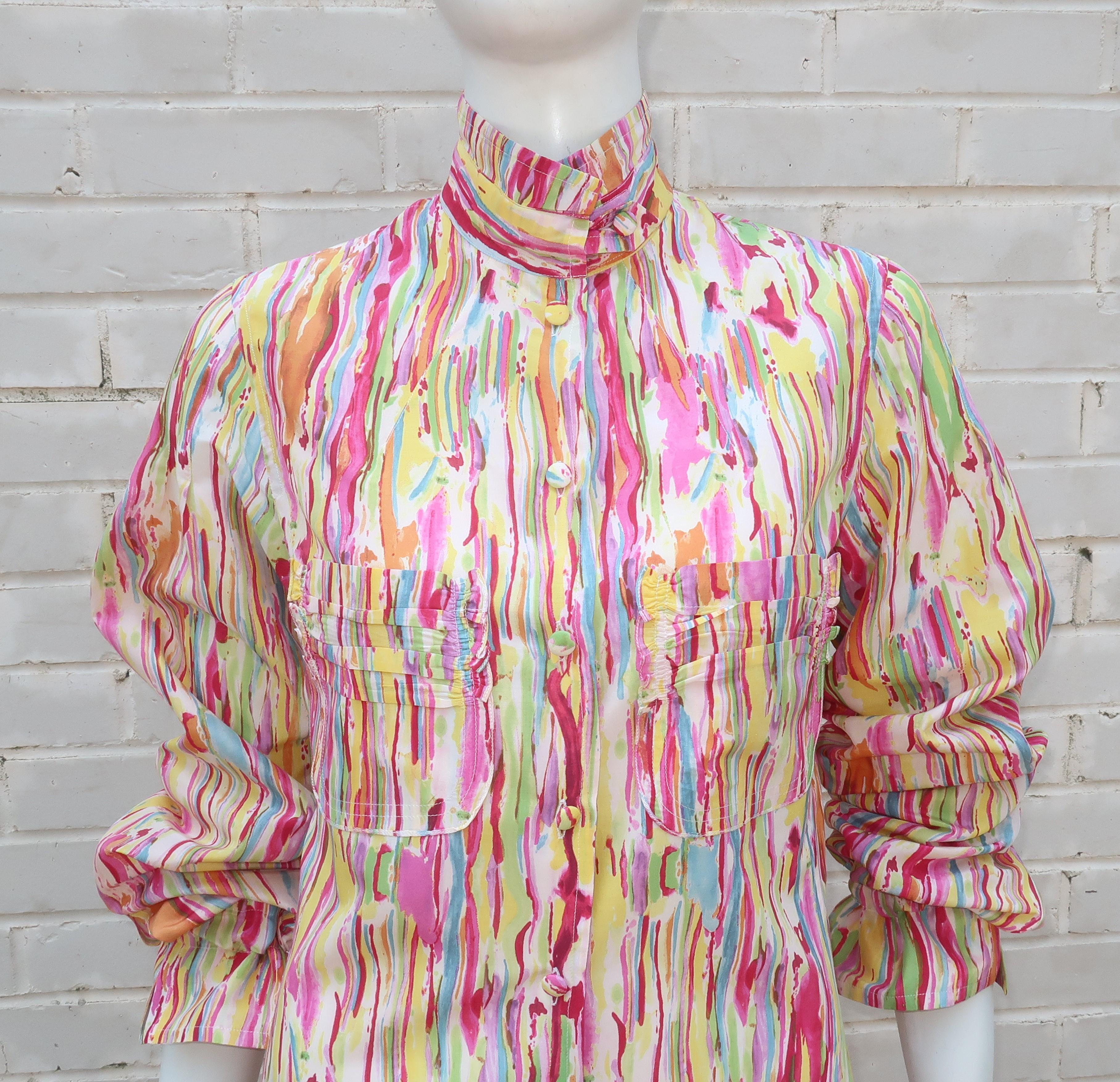 An Yves Saint Laurent silk blouse with an abstract pattern in shades of fuchsia, lilac, green, yellow, orange and white all resembling a cheerful watercolor painting.  The details add to the fun including pin tucking at the upper sleeves, ruched