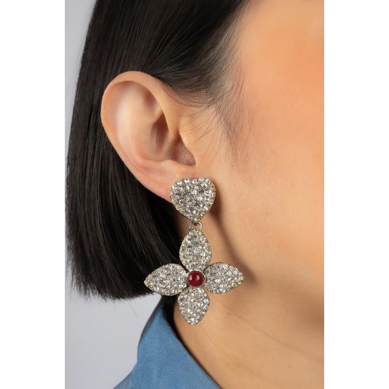 Yves Saint Laurent - (Made in France) Silvery metal clip-on earrings ornamented with rhinestones and a red glass paste cabochon.

Additional information:
Condition: Very good condition
Dimensions: Length: 6 cm

Seller Reference: BOB44
