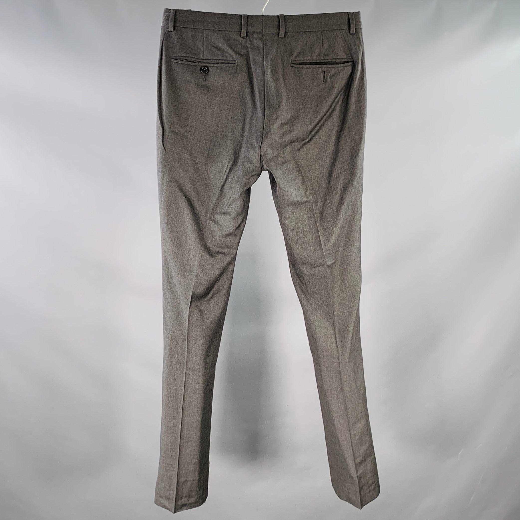 YVES SAINT LAURENT dress pants
in a charcoal grey wool featuring a flat front style, tapered leg, and zip fly closure. Made in Italy.Good Pre-Owned Condition. Missing one back pocket button, tiny hole. As is. 

Marked:   IT 46R 

Measurements: 
 