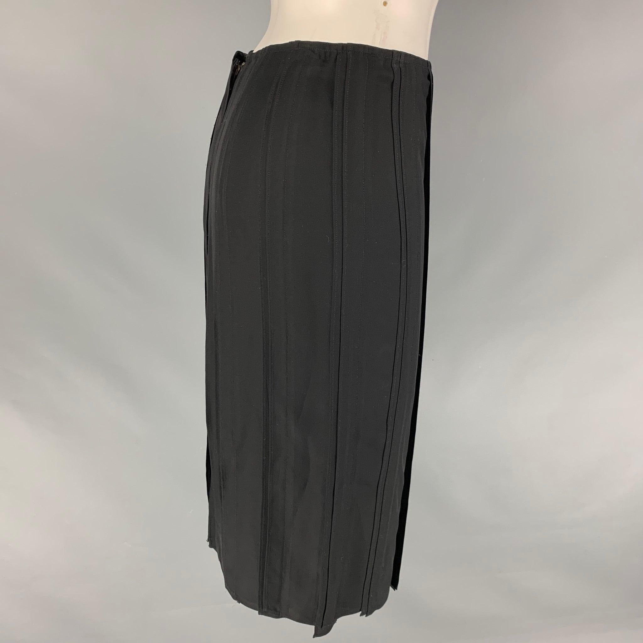 YVES SAINT LAURENT pencil skirt comes in a black silk material featuring a pleated style, and a center back zip up closure. Made in France.Excellent Pre-Owned Condition.  

Marked:   36 

Measurements: 
  Waist: 27 inches Hip: 34 inches Length: 25