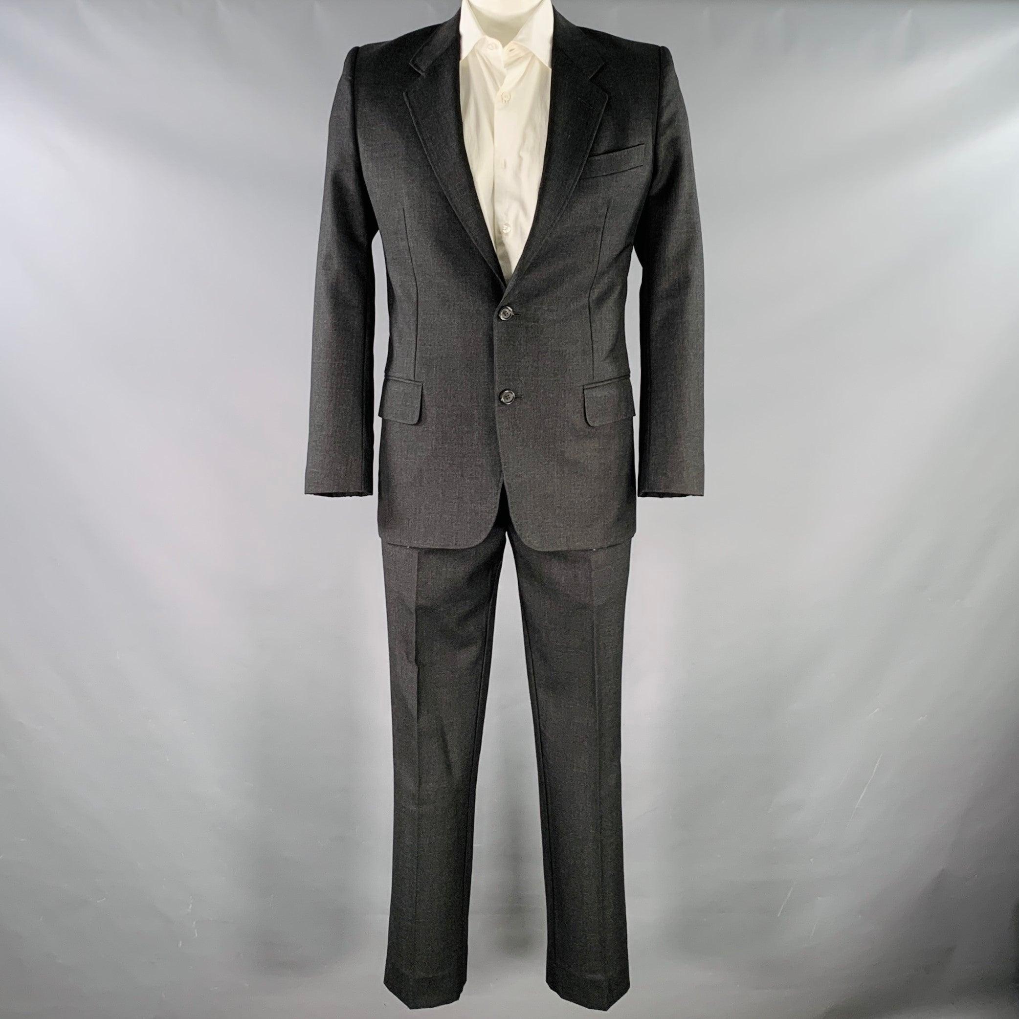 YVES SAINT LAURENT suit
in a charcoal grey wool with a full liner and includes a single breasted, double button sport coat with a notch lapel and matching flat front trousers. Made in Italy.Very Good Pre-Owned Condition. Some marks inside of pants,