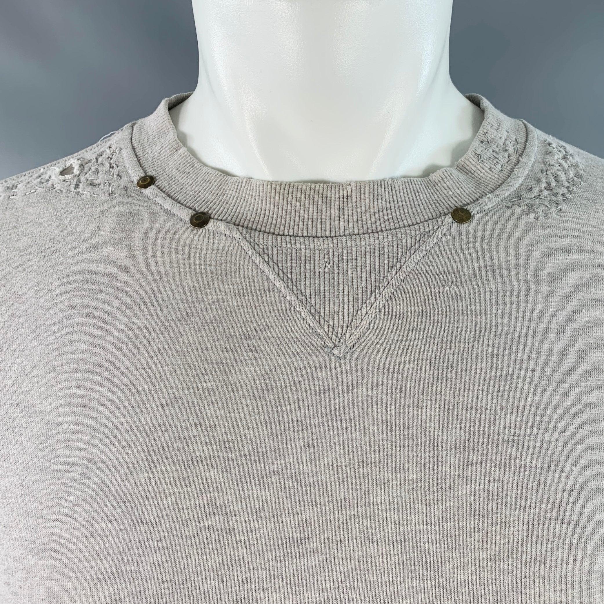 YVES SAINT LAURENT sweatshirt
in a heather grey cotton featuring a visible mending-style distressed design, brass metal stud details, and crew neck. Made in Italy.Excellent Pre-Owned Condition. Distress is an intentional part of design. 

Marked:  