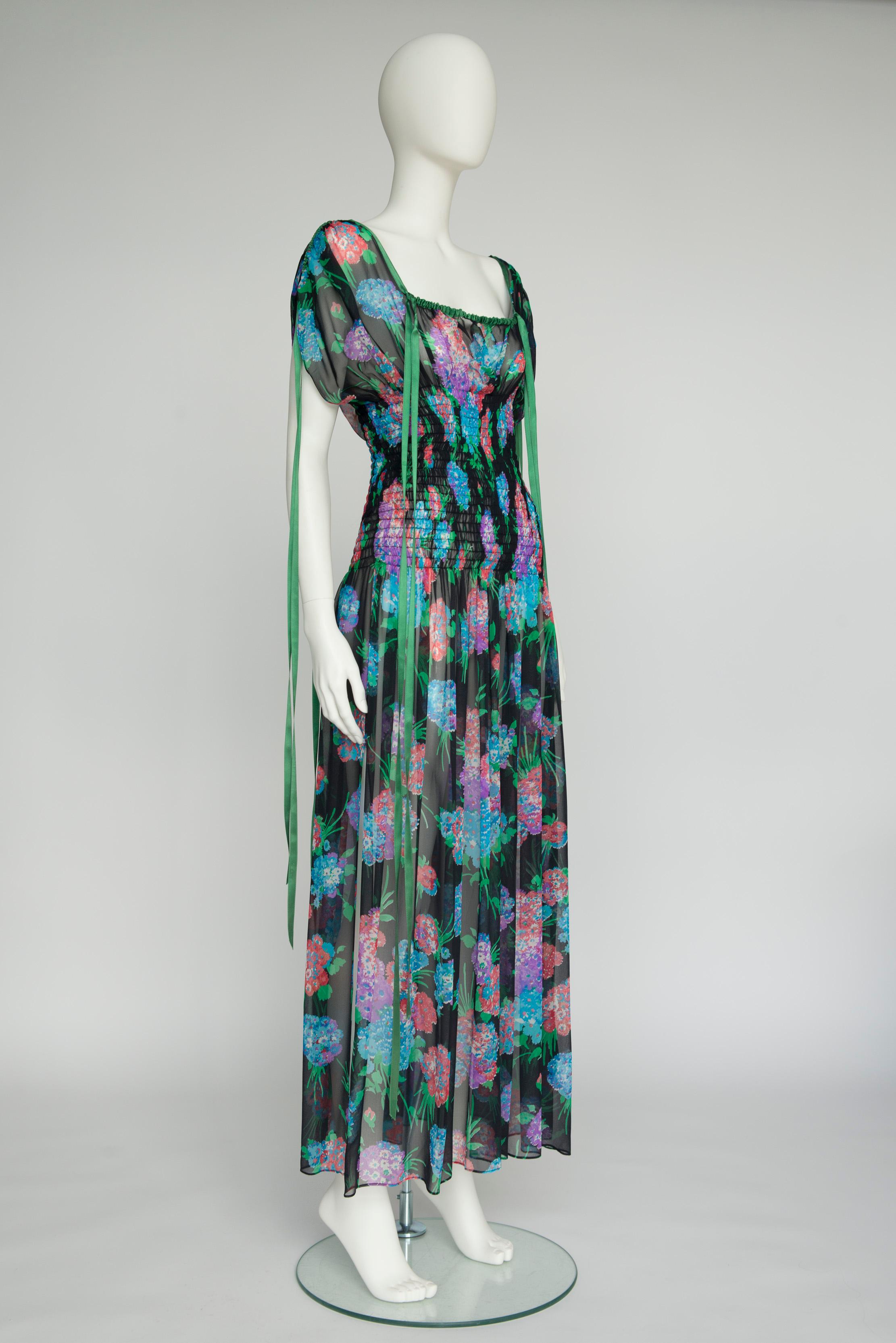 Cut from airy sheer silk chiffon, this rare early 70s Saint Laurent Rive Gauche maxi dress is shirred from under the chest to the hips for a flattering - though comfortable - closer fit. Around the neckline and on the sleeves, adjustable green silk