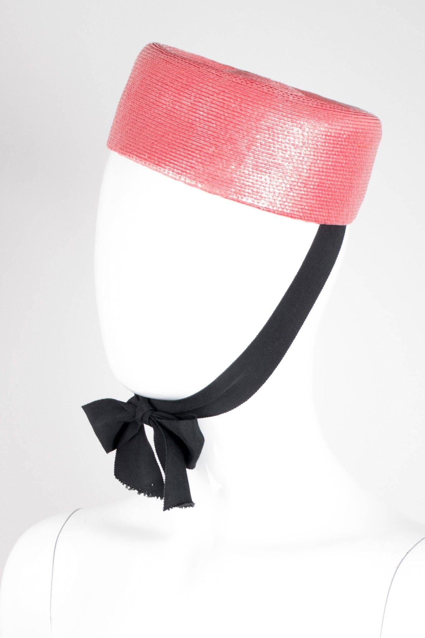 Cheeky straw pillbox hat by Yves Saint Laurent. Live out your Jackie O fantasies in this little ribbon-tied pillbox hat in a bright, cheerful color. We would update the look for daily use and wear with jeans, a cropped boxy jacket, and a pair of