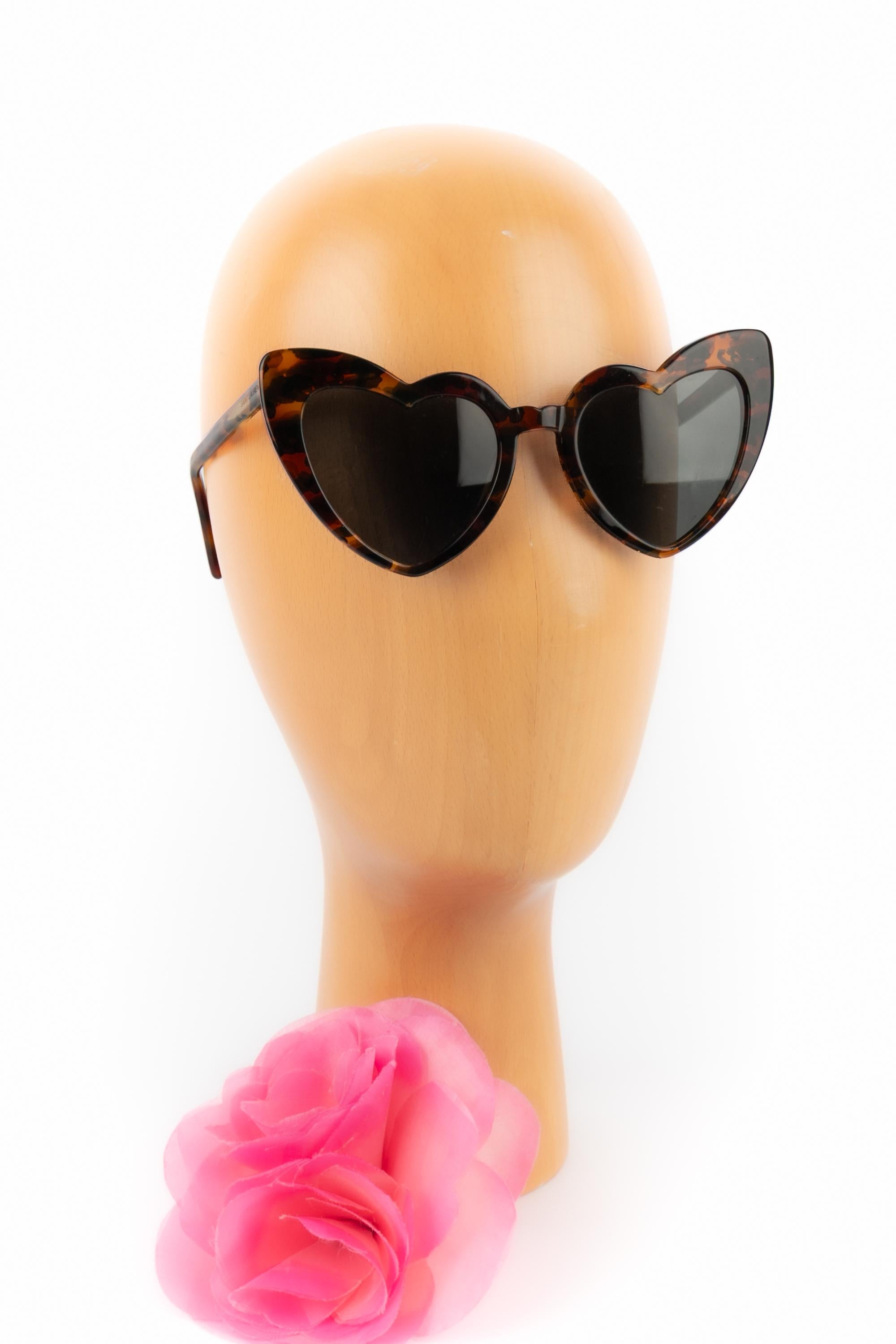 YVES SAINT LAURENT -(Made in Italy) Sonnenbrille aus schildpattfarbenem Bakelit mit Herzen. Loulou Design.

Bedingung:
Sehr guter Zustand

Abmessungen:
Länge: 14,5 cm - Höhe: 7 cm

SKU:ACC6