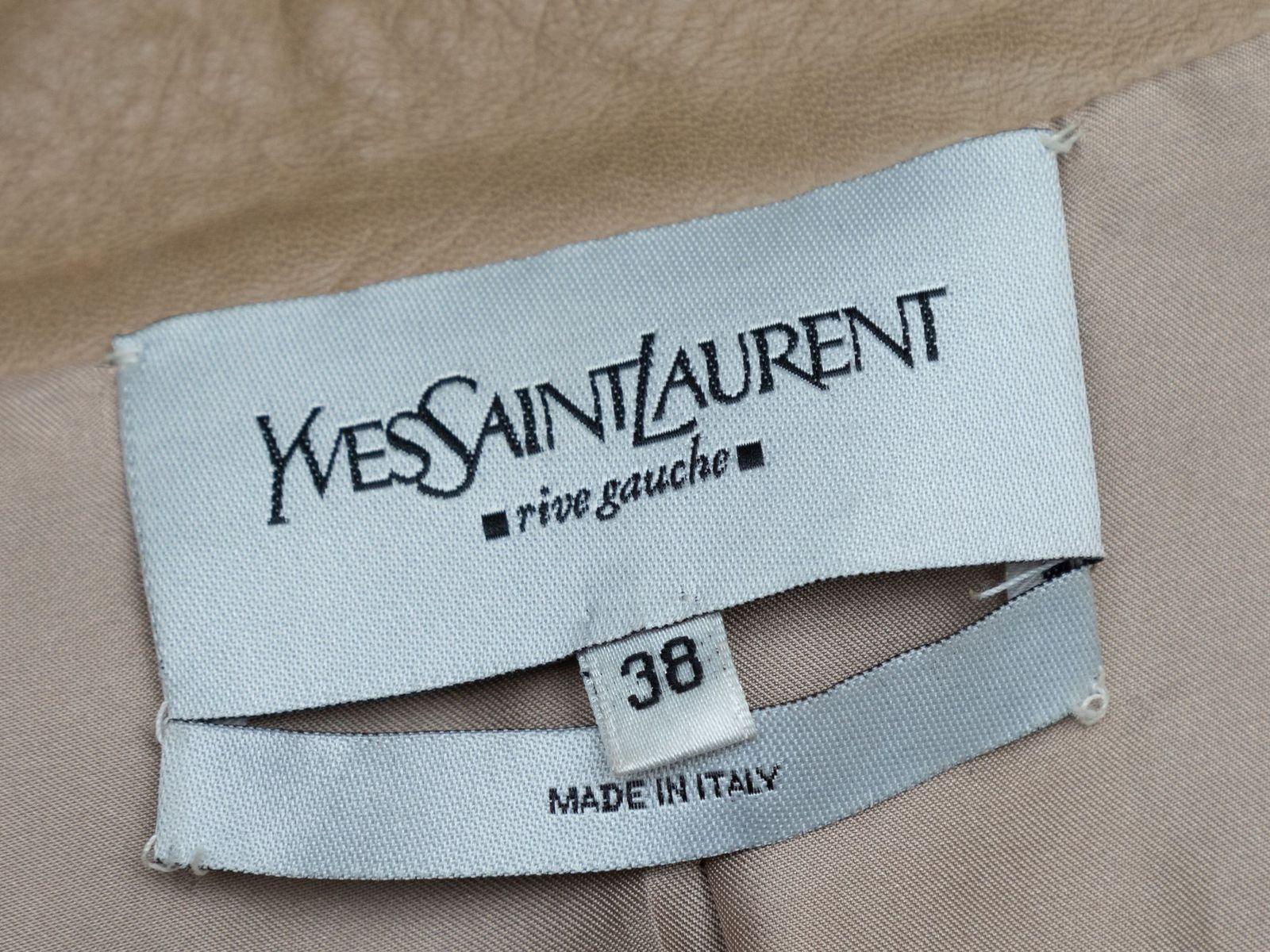 Product Details: Tan stand collar leather jacket by Yves Saint Laurent. Four pockets. Tie at waist. Concealed button closures at front. Designer size 38. 30