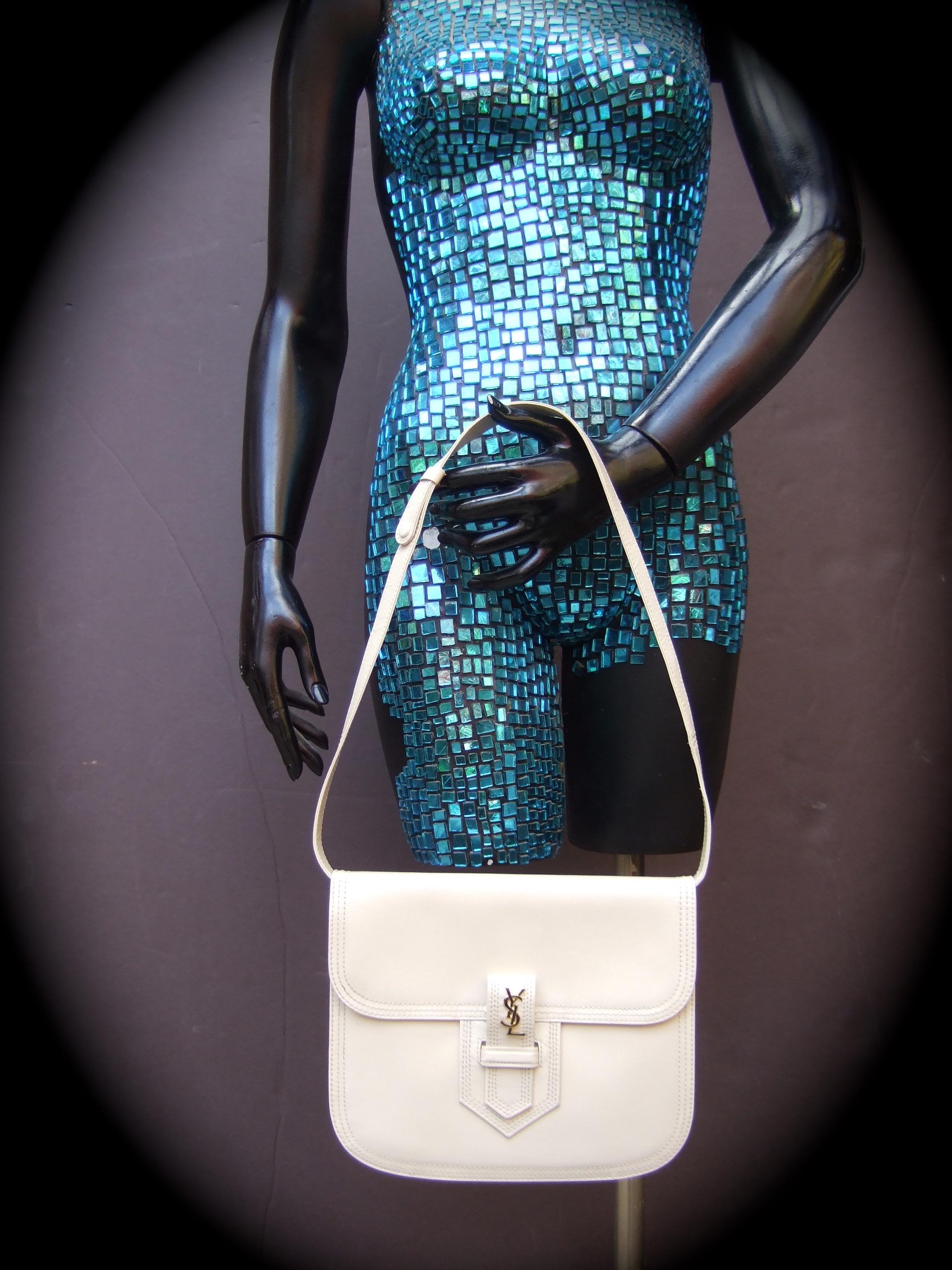 Yves Saint Laurent Chic taupe - bone color leather versatile handbag c 1980s 
The unique small size handbag converts from a chic clutch bag into a stylish
shoulder bag carried with the detachable matching  leather shoulder strap 

Adorned with Saint