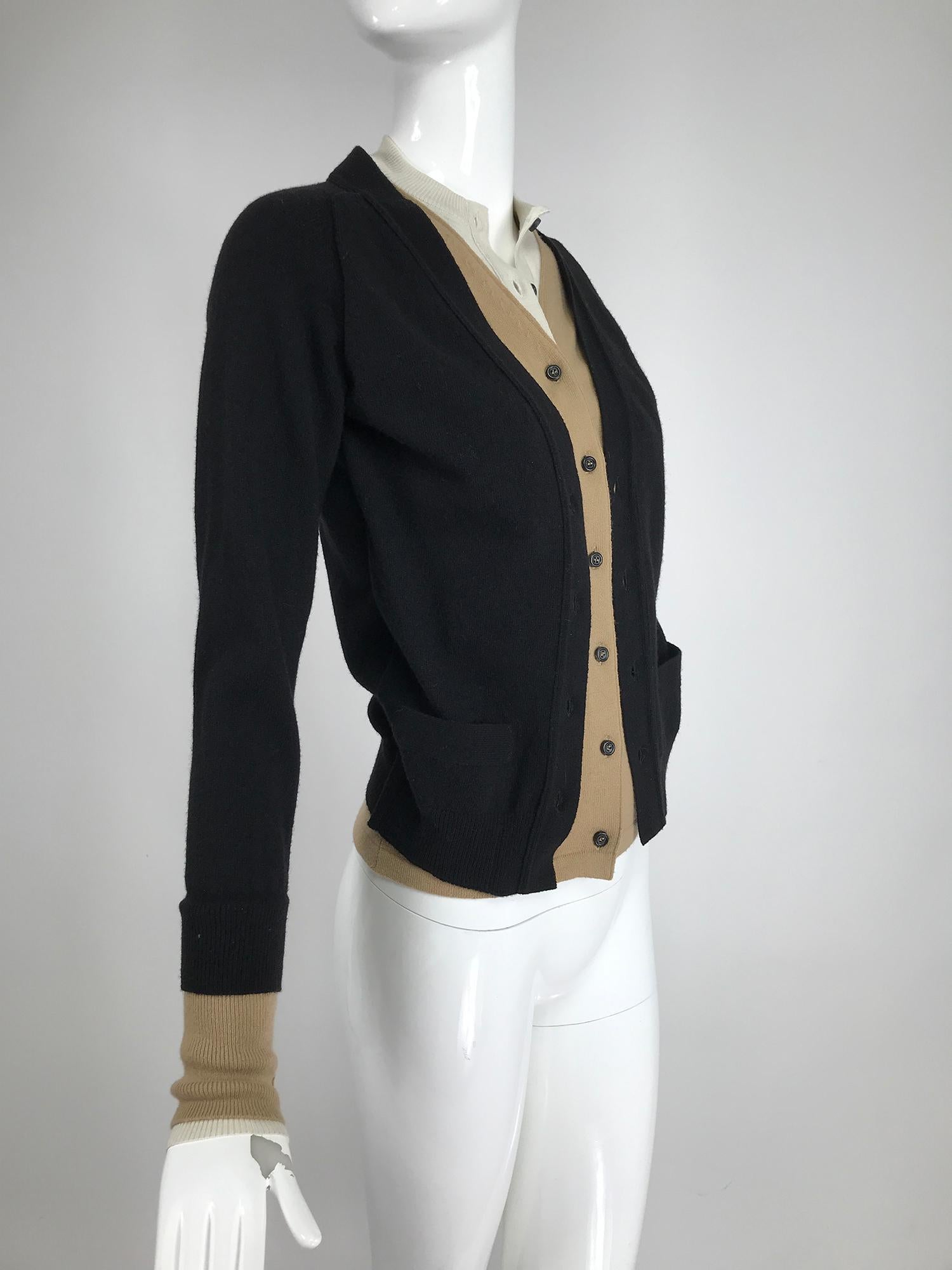 Yves Saint Laurent three in one cropped cardigan sweater. The outer sweater is black, with a v neck front, long sleeves and small front pockets. Ribbed hem and cuffs. The tan layer is only a facing that is stitched to the black sweater, it features