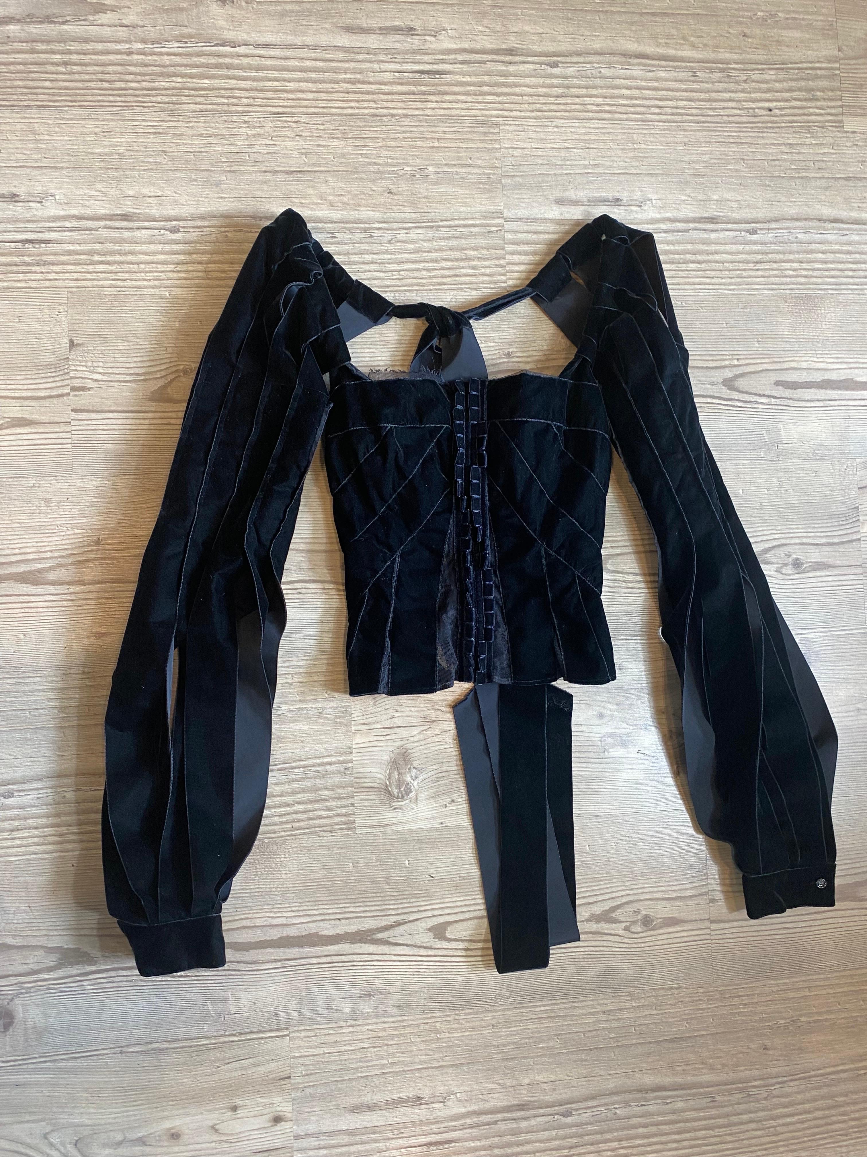 Yves Saint Laurent velvet corset top 
Yves Saint Laurent collection by Tom Ford FW 2002.
A runway and archive piece. Sleeves with bottom closed by logoed button.
Interior detail of the retina. Corset-style front hook closure.
Size Fr 34.
Sleeve