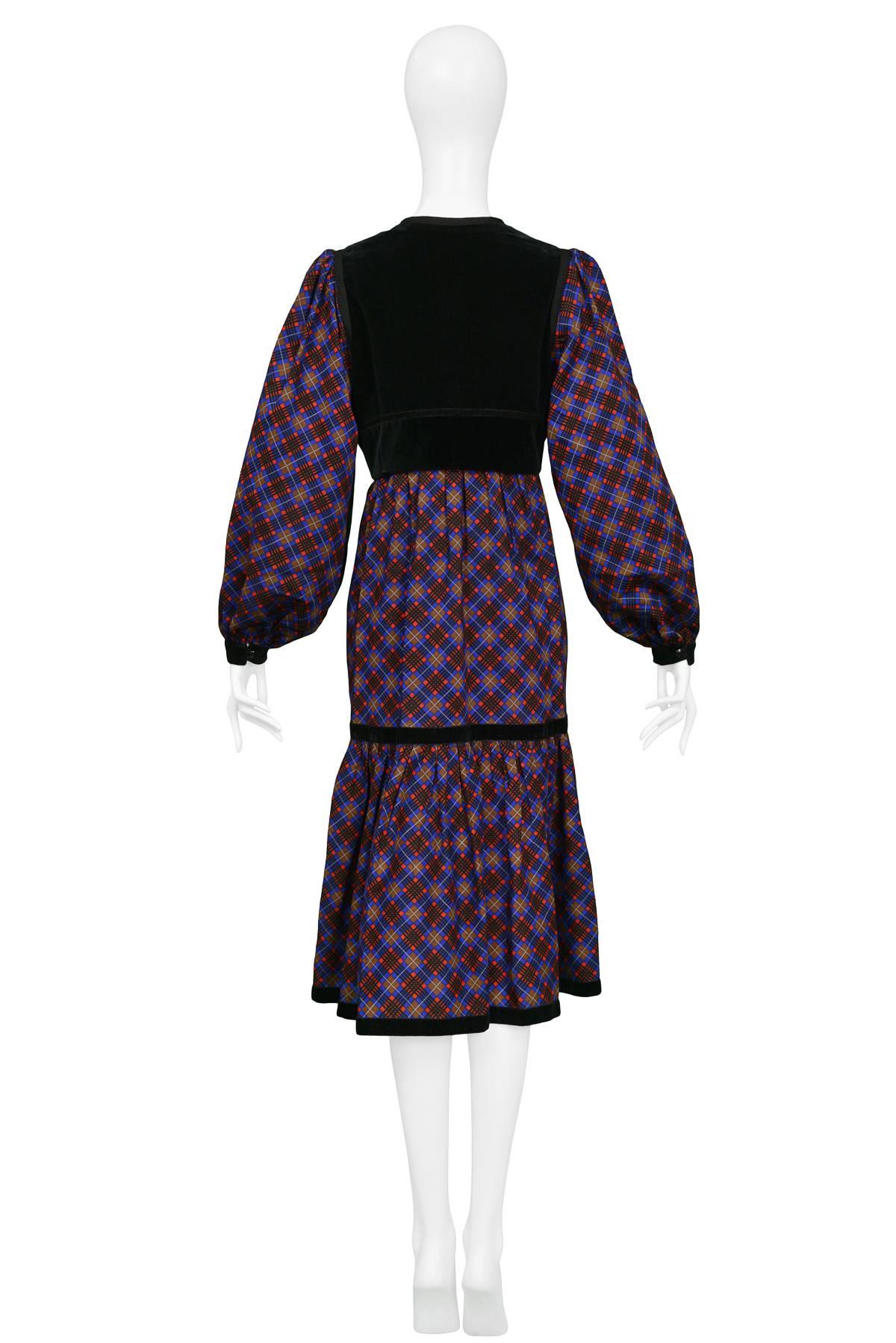 YVES SAINT LAURENT

VELVET & PLAID SMOCK DRESS
Condition : Excellent Vintage Condition
Vintage Yves Saint Laurent red, blue & brown wool plaid smock dress featuring a black velvet yoke with button closure at chest and black velvet cuffs and trim to