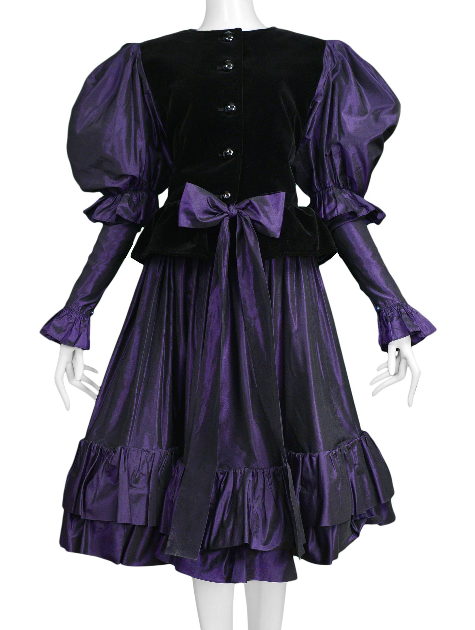 Resurrection Vintage is excited to offer a vintage Yves Saint Laurent purple taffeta ensemble featuring a button front jacket with black velvet paneling in the front and back, purple puffed sleeves, and a matching purple taffeta skirt with a ruffle
