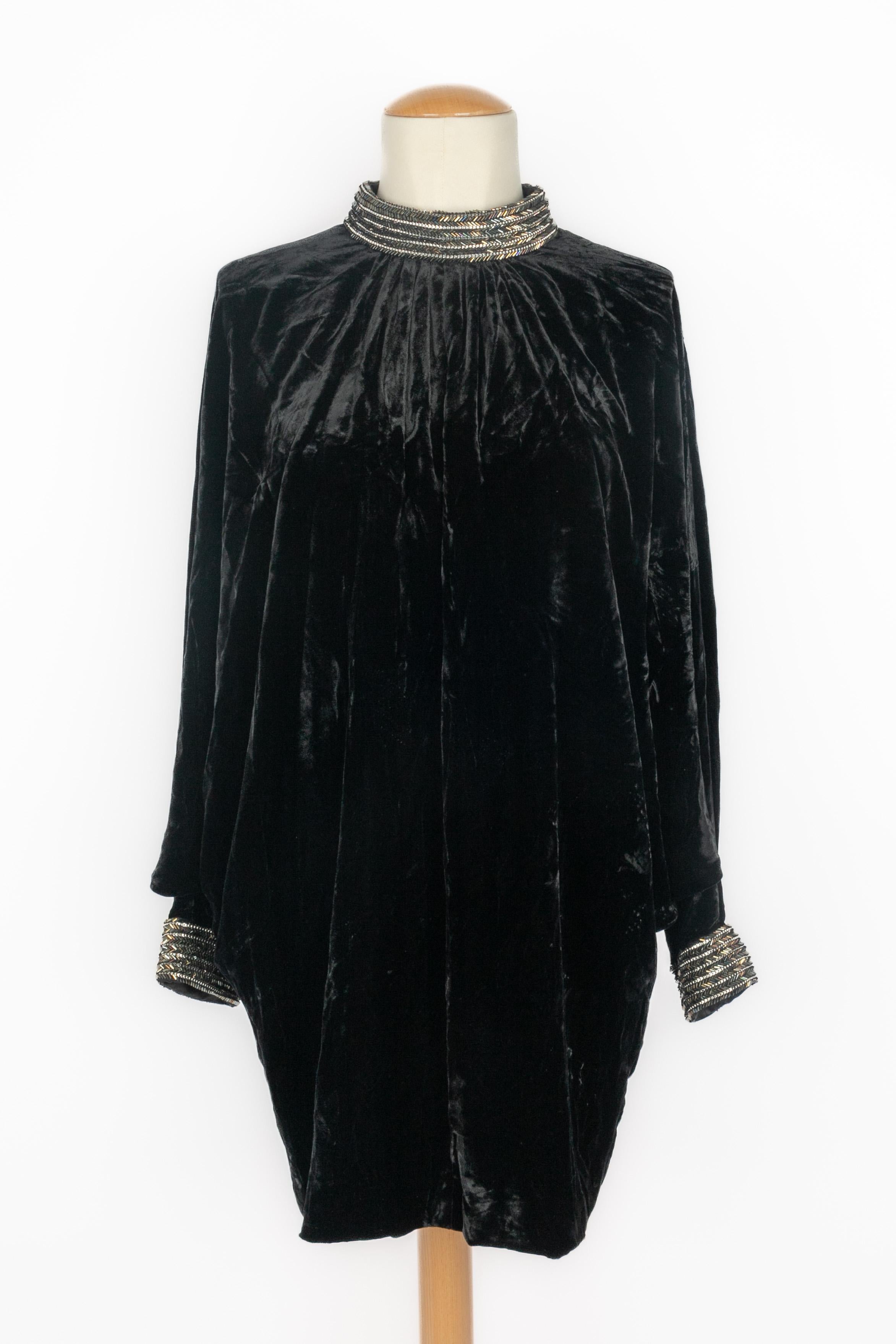YVES SAINT LAURENT - Long black velvet tunic with a high neck edged with pearl rows. Bat sleeves and embroidered wrists. Back zip fastening. Size 40.

Condition:
Very good condition

Dimensions:
Shoulder width: 42 cm - Sleeve length: 60 cm - Length:
