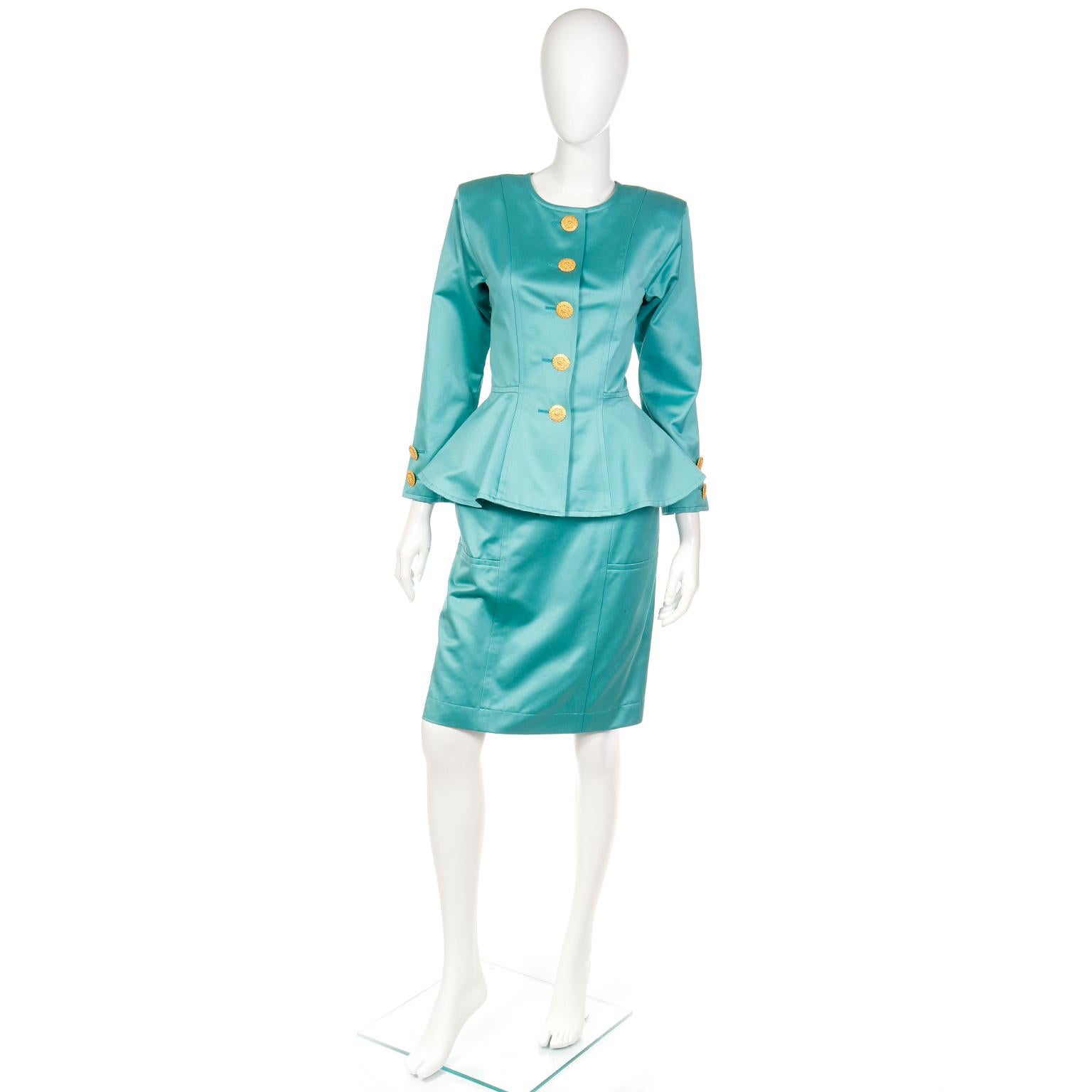 We love vintage Yves Saint Laurent and find that his pieces truly stand the test of time! This is a 1991 Deadstock YSL two piece green polished cotton suit with a collarless peplum jacket and straight skirt. 
The pretty peplum jacket has princess
