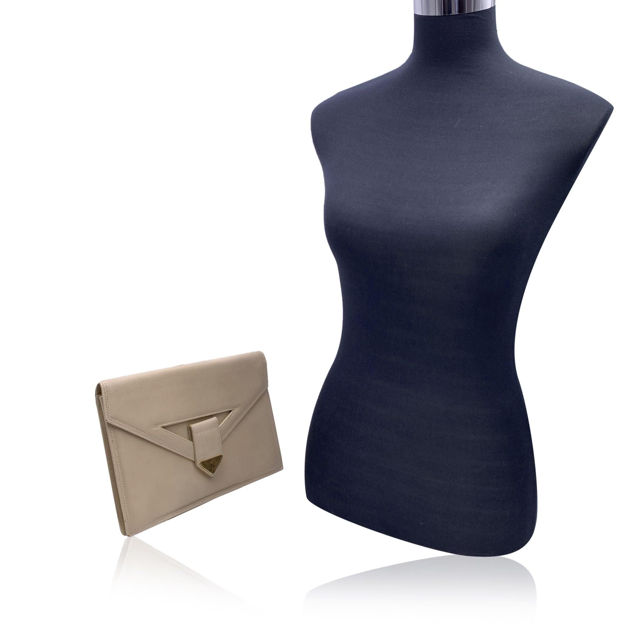 Yves Saint Laurent Vintage Clutch Bag aus beigefarbenem Leder. Sie hat eine Klappe mit Magnetknopfverschluss auf der Vorderseite. Goldene Metalllasche mit YSL-Logo auf der Vorderseite. 1 offene Tasche hinten. Braunes Stofffutter. 1 Seitentasche mit