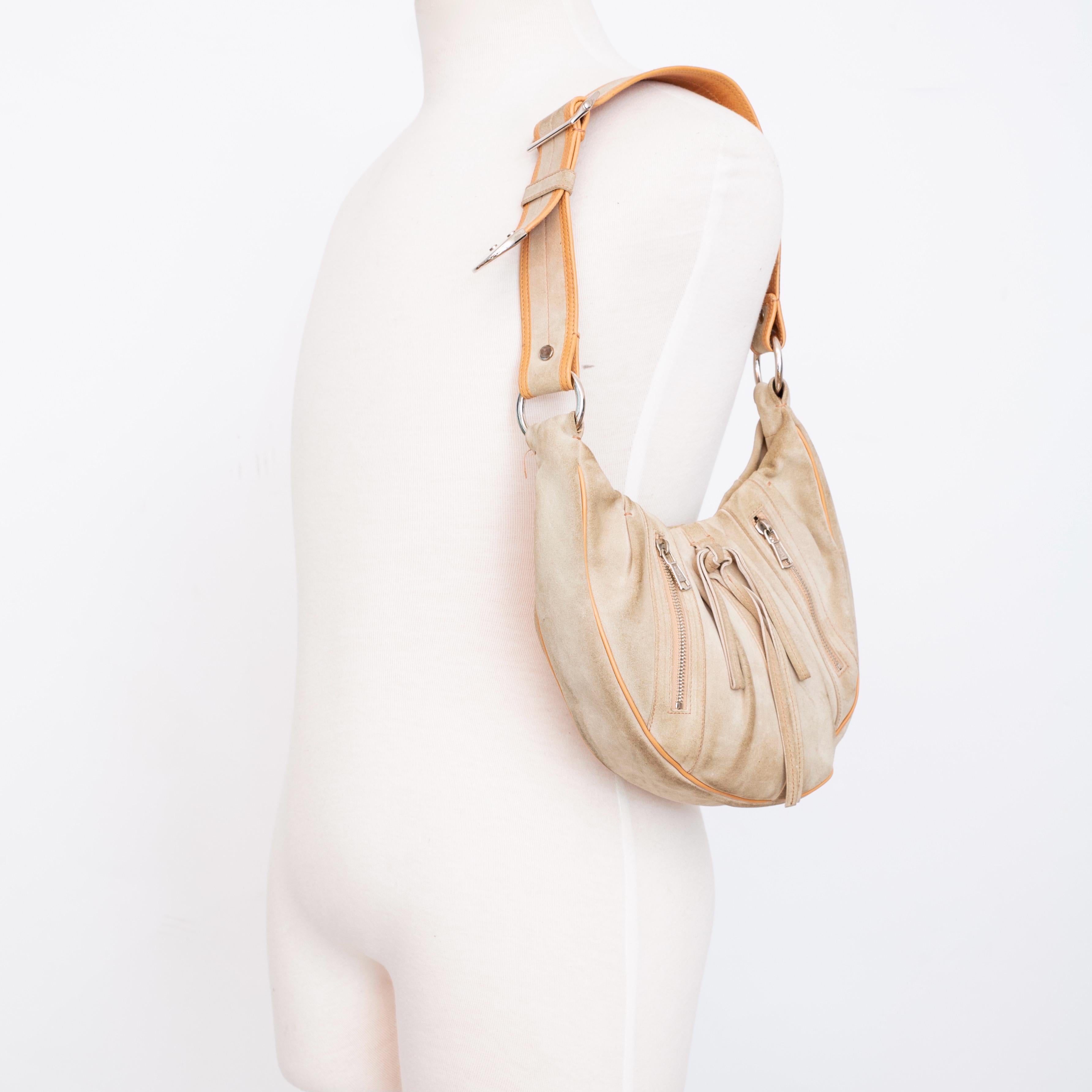 This vintage YSL hobo bag comes in an aged beige colour, with brown contrasting stitching throughout. Featuring sliver hardware, snap closure and a black interior with a zip pocket.

COLOR: Beige
MATERIAL: Suede
ITEM CODE: 120436 001998
MEASURES: H