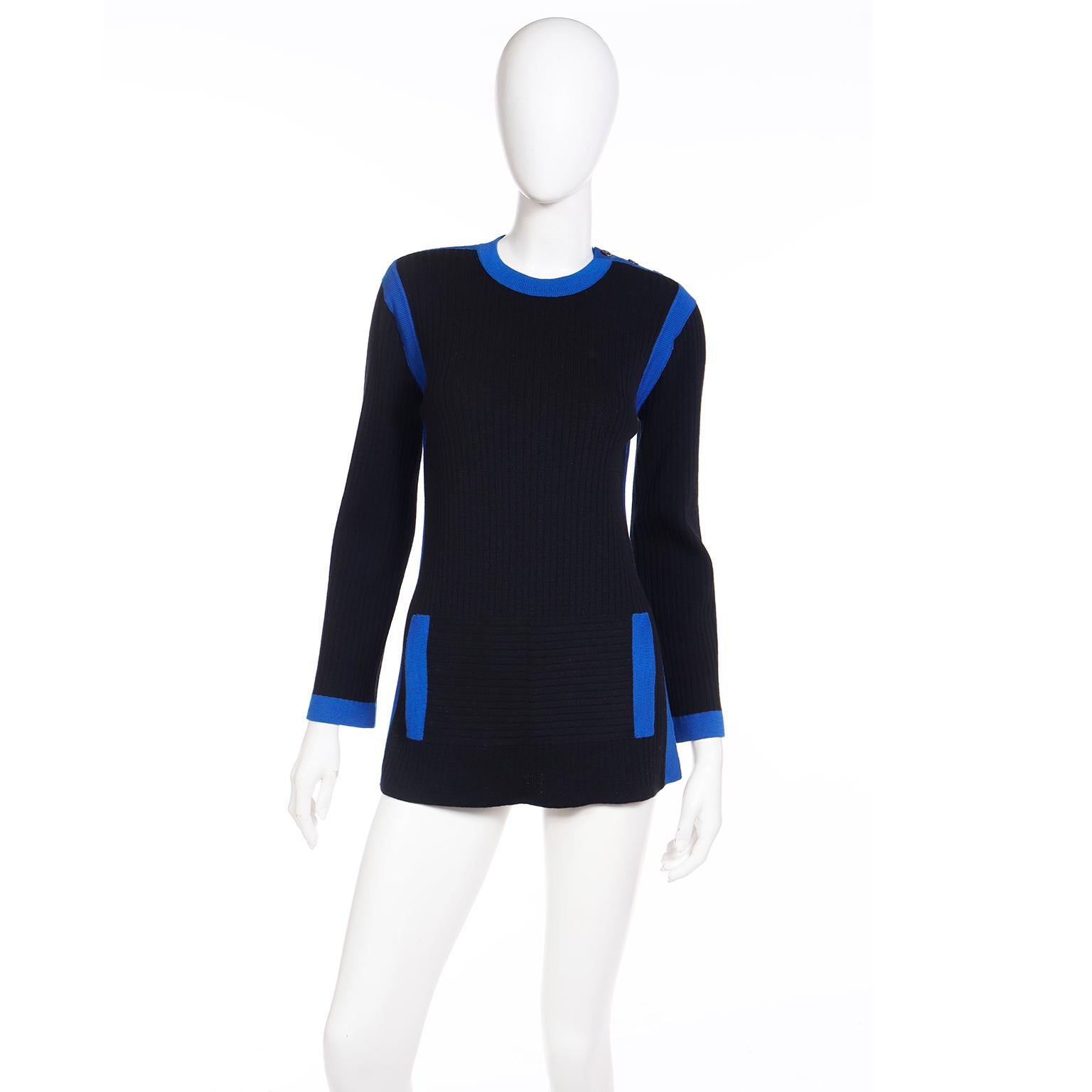 Dies ist ein YSL 1980's Vintage Pullover von Yves Saint Laurent in schwarz gerippt Wolle stricken mit schönen hellblau trimmen. Dieses lange Oberteil hat Schlitze an beiden Seiten und falsche Taschen auf der Vorderseite. An den Schultern befinden