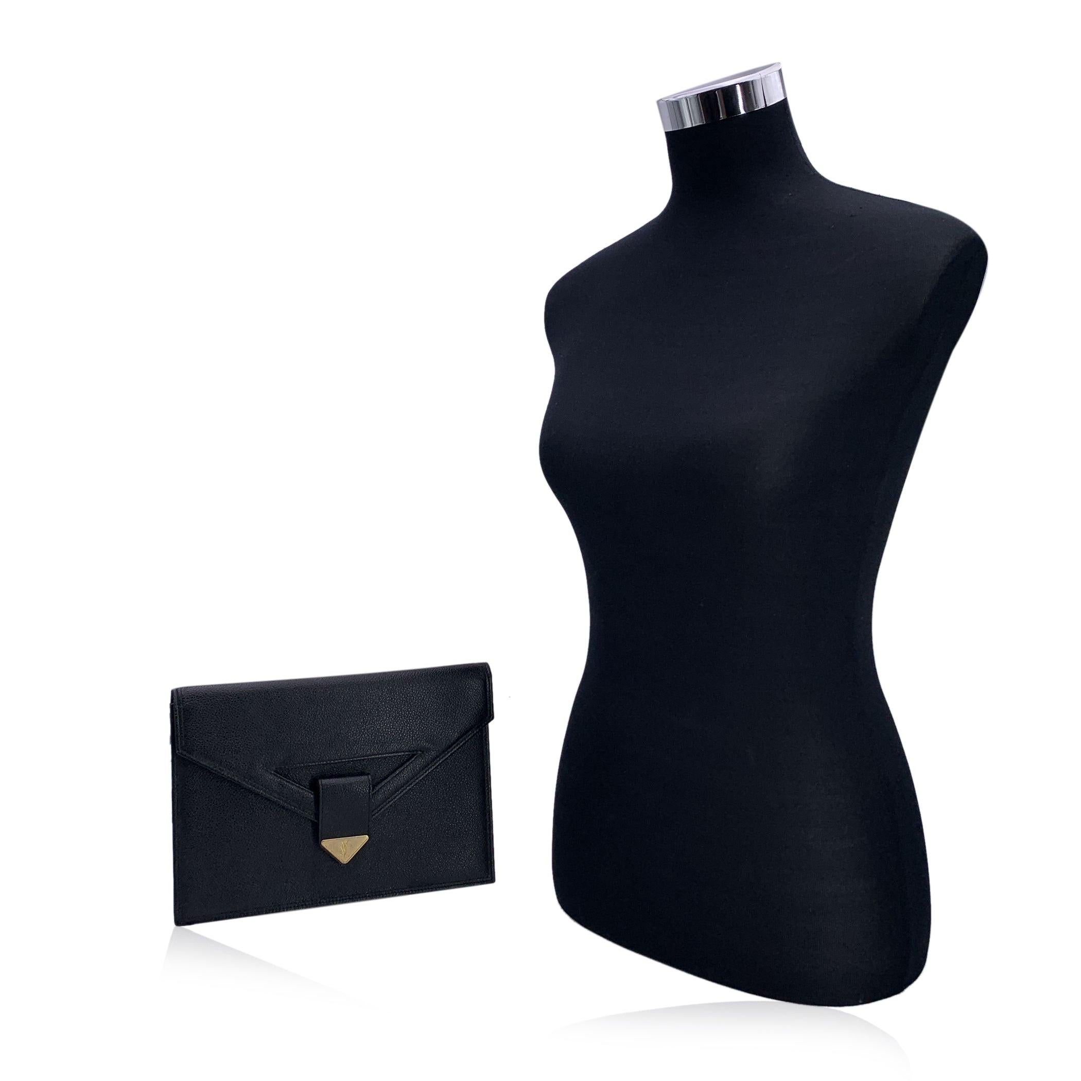 Yves Saint Laurent vintage clutch bag, crafted in black leather. It features a flap with magnetic button closure on the front. Gold metal YSL logo tab on the front. 1 rear open pocket. Black fabric lining. 1 side zip pocket inside. 'YVES SAINT