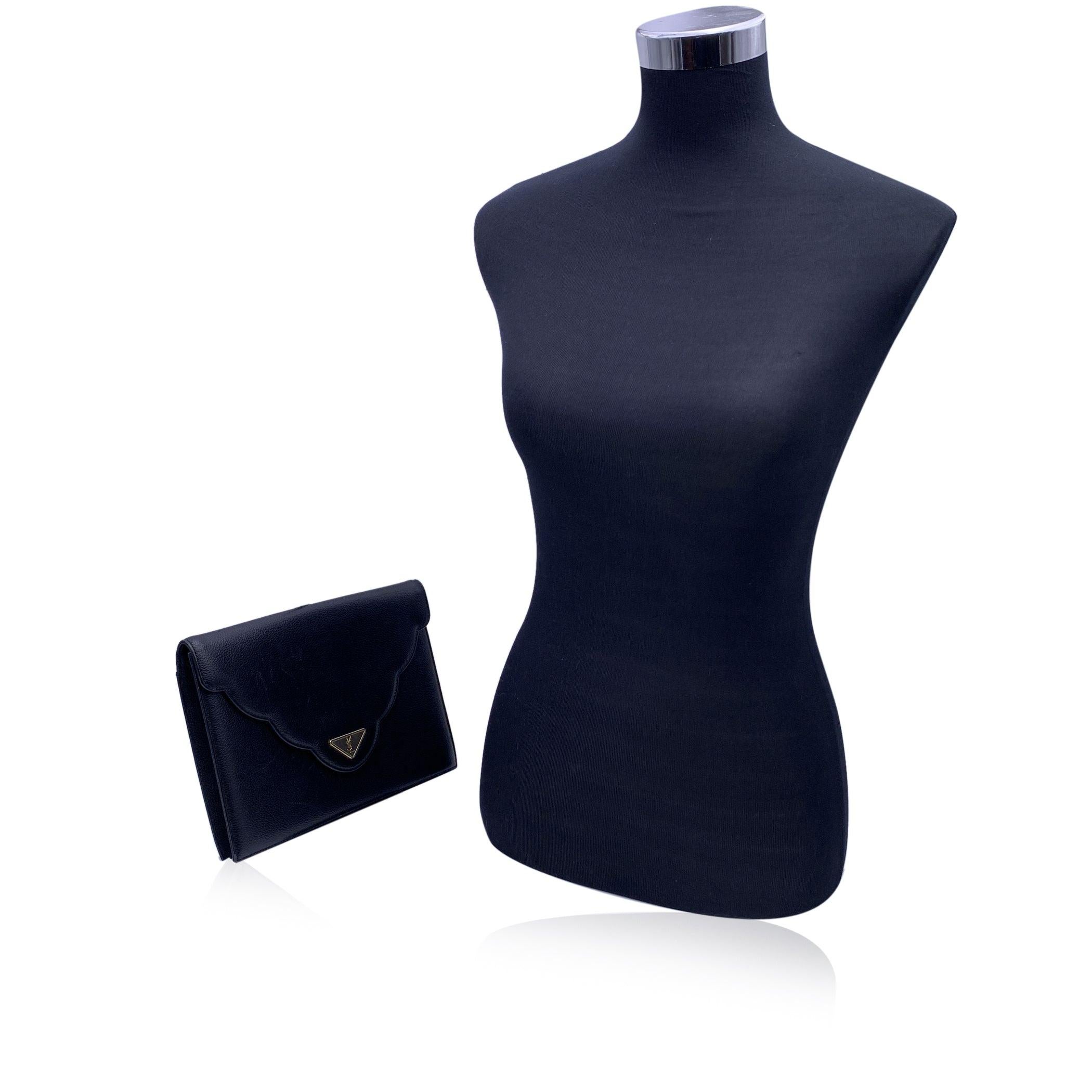 This Yves Saint Laurent vintage clutch bag is a stunning embodiment of timeless elegance and refined luxury. Crafted from black leather, the bag exudes a classic sophistication that never goes out of style. The sleek flap design, secured with a