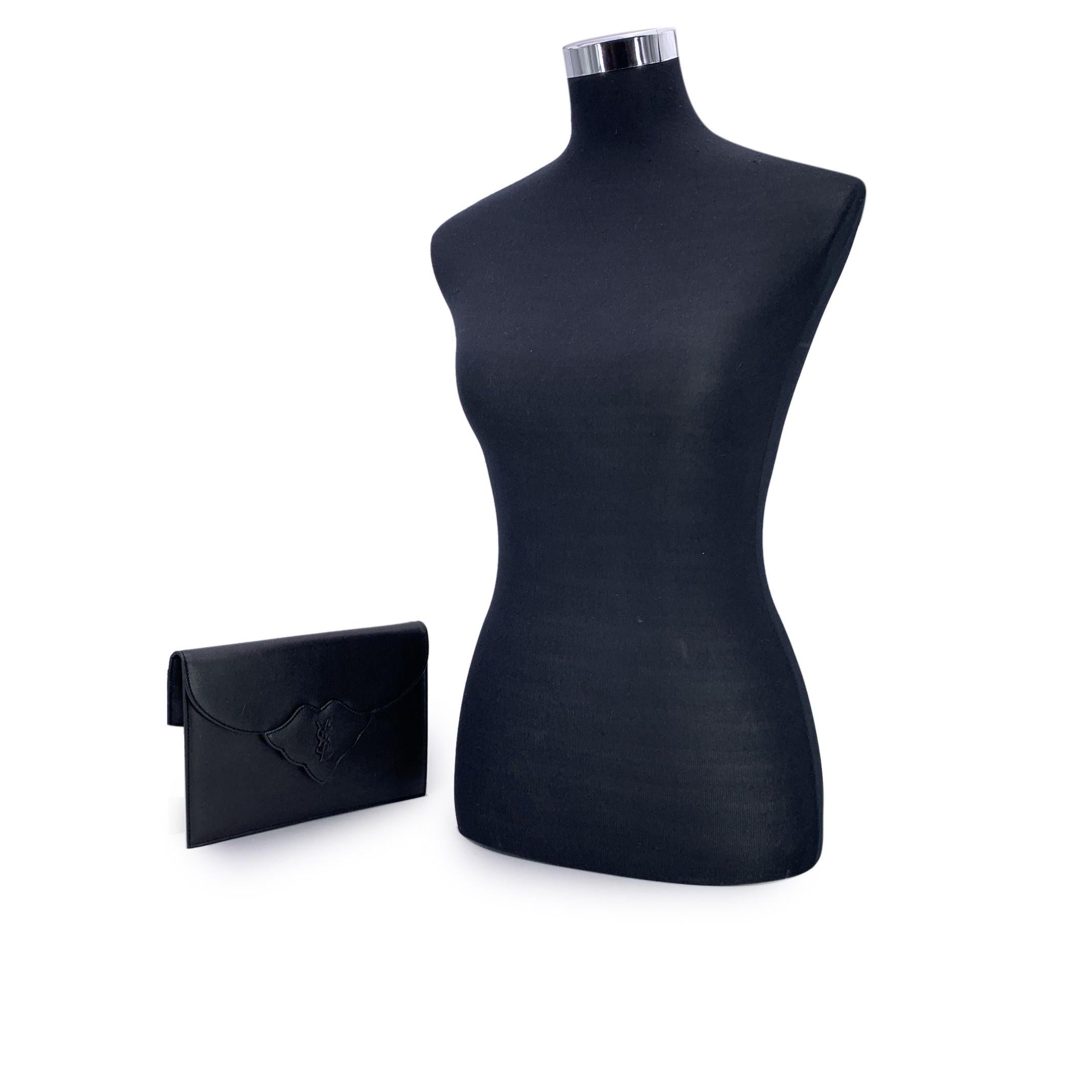 Step into timeless elegance with this vintage Yves Saint Laurent clutch bag - a true emblem of classic Parisian sophistication. Crafted in supple black leather, this refined piece echoes the understated glamour of eras past. The structured