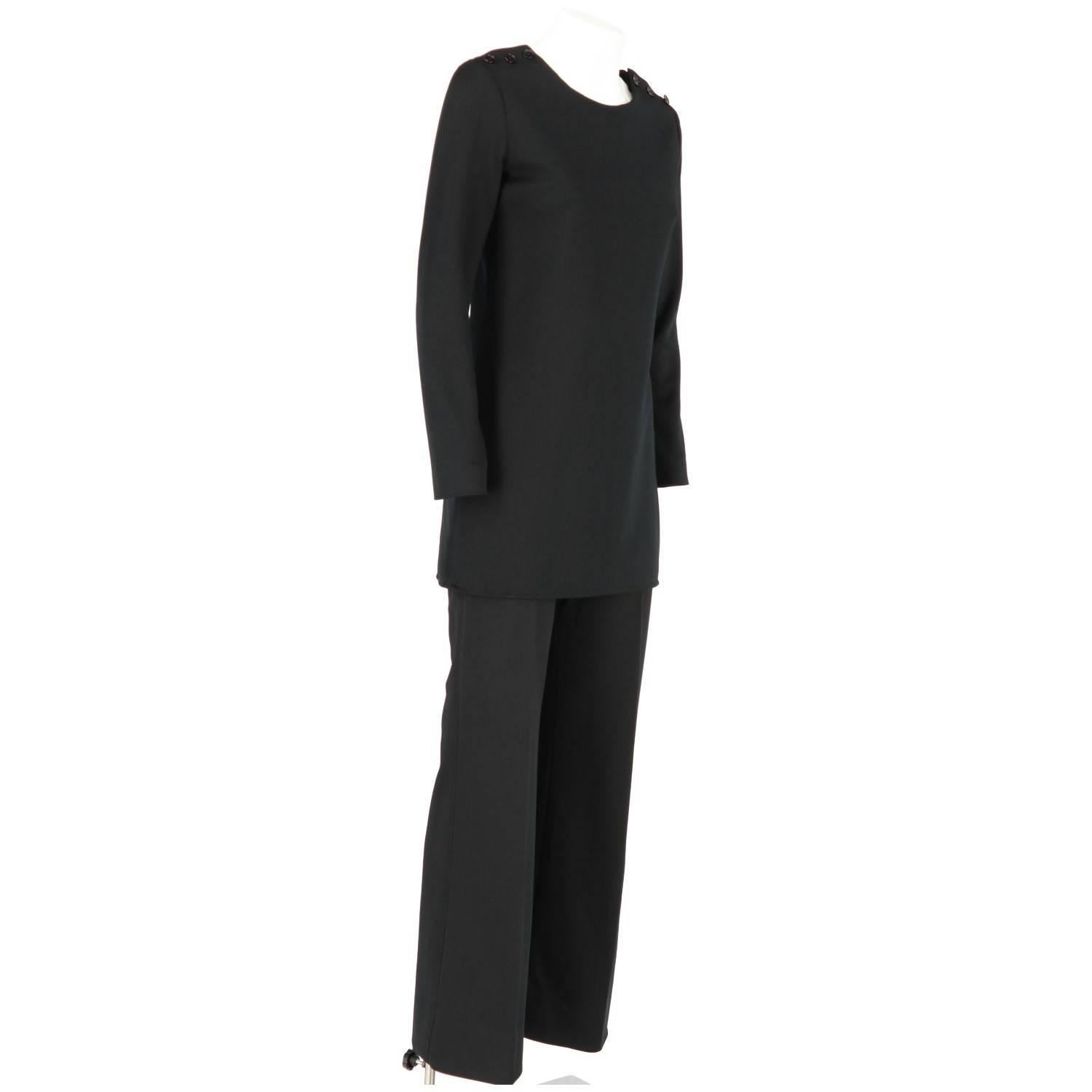 Elegant Yves Saint Laurent black design suit with buttoned blouse and trousers.

Top
Height: 76 cm
Shoulders: 35 cm
Bust: 42 cm
Sleeves: 57 cm

Trousers
Height: 102 cm
Waist: 29 cm
