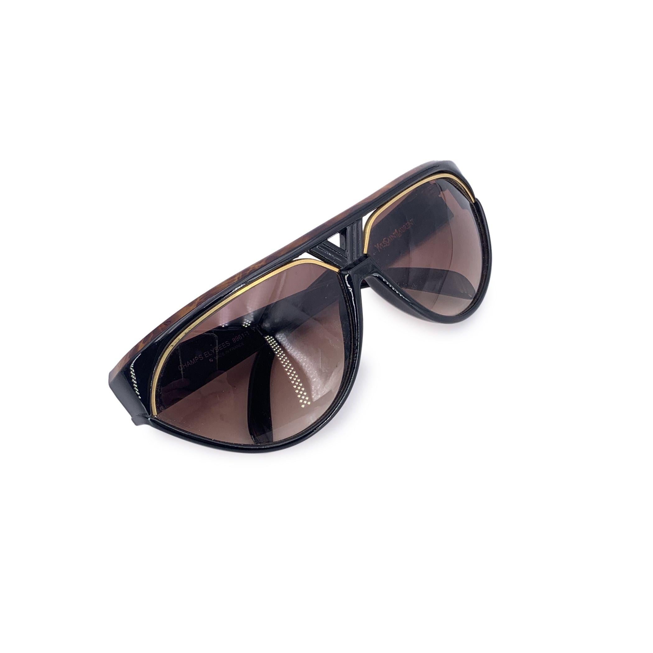 Bold, sculptural, and utterly unmistakable-these Yves Saint Laurent Vintage Champs Élysées 8961-1 Sunglasses are a love letter to the fearless fashion of 1980s Paris. Named after the famed boulevard that epitomizes elegance and grandeur, the Champs