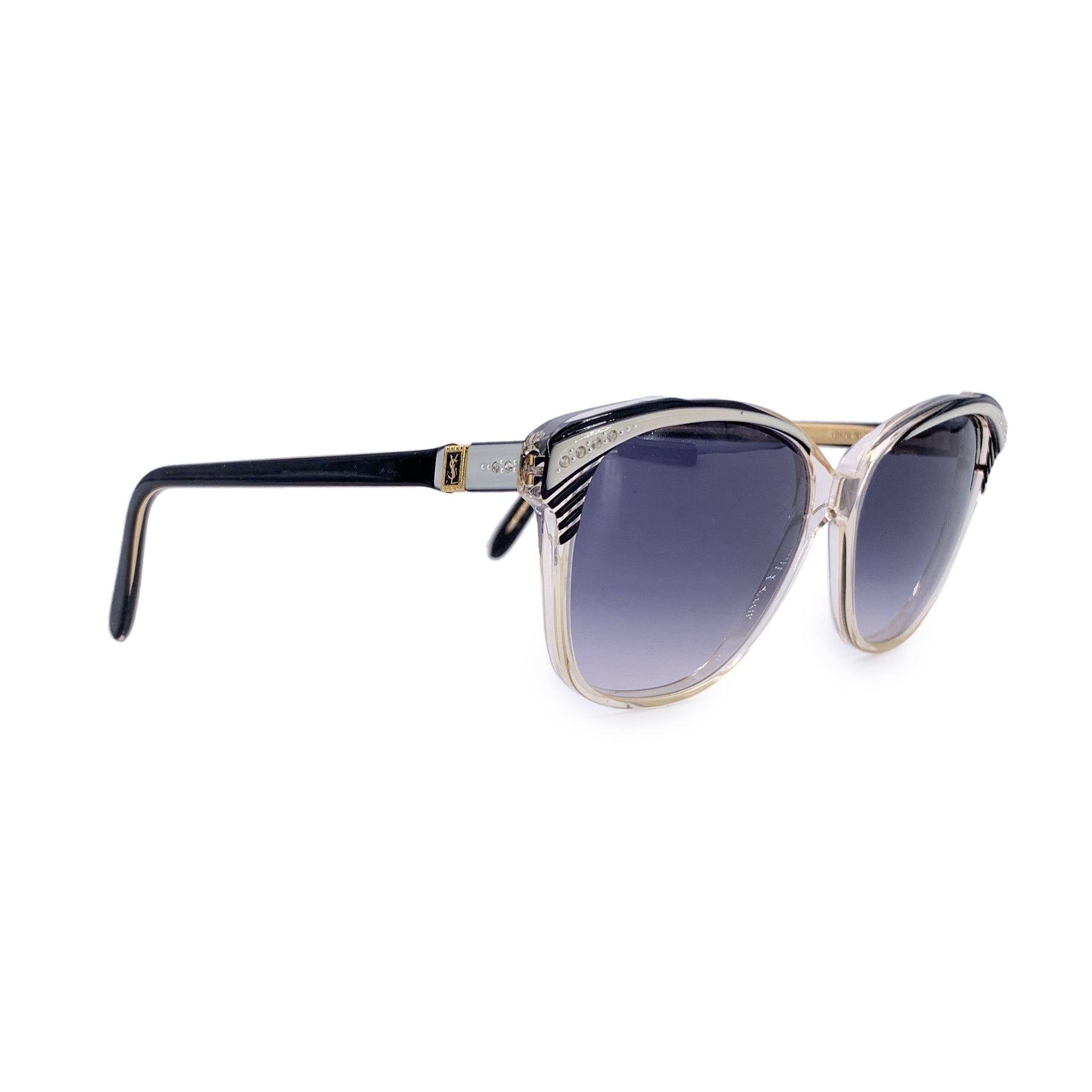 Ein wahres Statement avantgardistischer Eleganz ist diese Vintage-Sonnenbrille von Yves Saint Laurent, Modell SOPHOCLE, ein seltener Fund aus dem goldenen Zeitalter der französischen Couture-Brillen. Der in Frankreich handgefertigte Rahmen aus