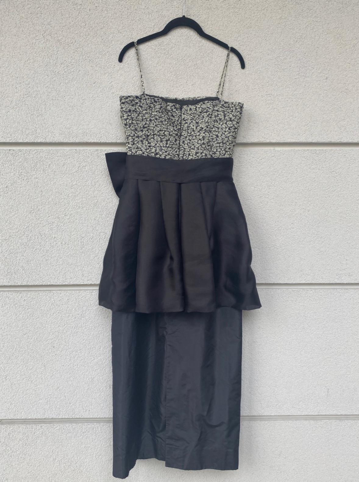 Yves Saint Laurent, Vestido Rive Gauche.
En seda negra con un estampado blanco y negro en la parte superior y un gran lazo ornamental.
Cierre de cremallera en la espalda.
Talla 42 Italiana 
Busto 40 cm
Cintura 36 cm
Largo 120 cm
Pieza vintage pero