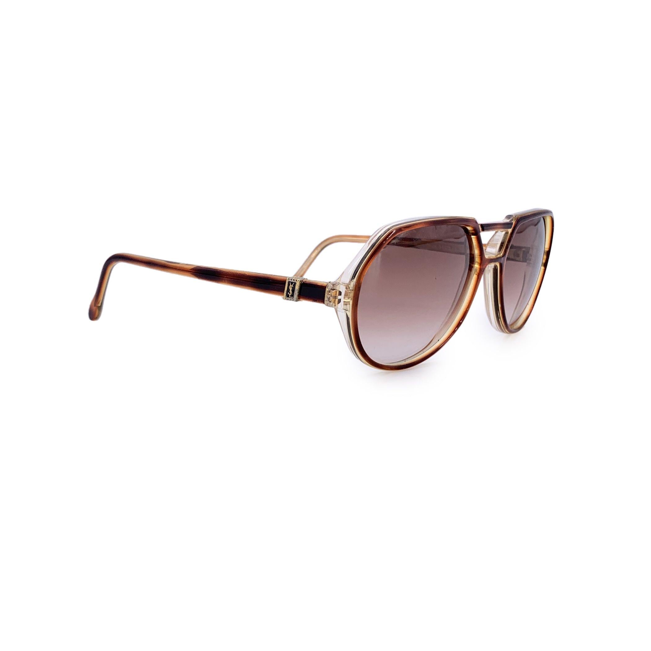 Mit dieser Vintage-Sonnenbrille von YVES SAINT LAURENT, einem seltenen Fundstück aus den späten 1970er bis frühen 1980er Jahren, werden Sie in die Vergangenheit zurückversetzt. Das Modell THOE fängt mit seinem warmen braunen Pilotengestell die