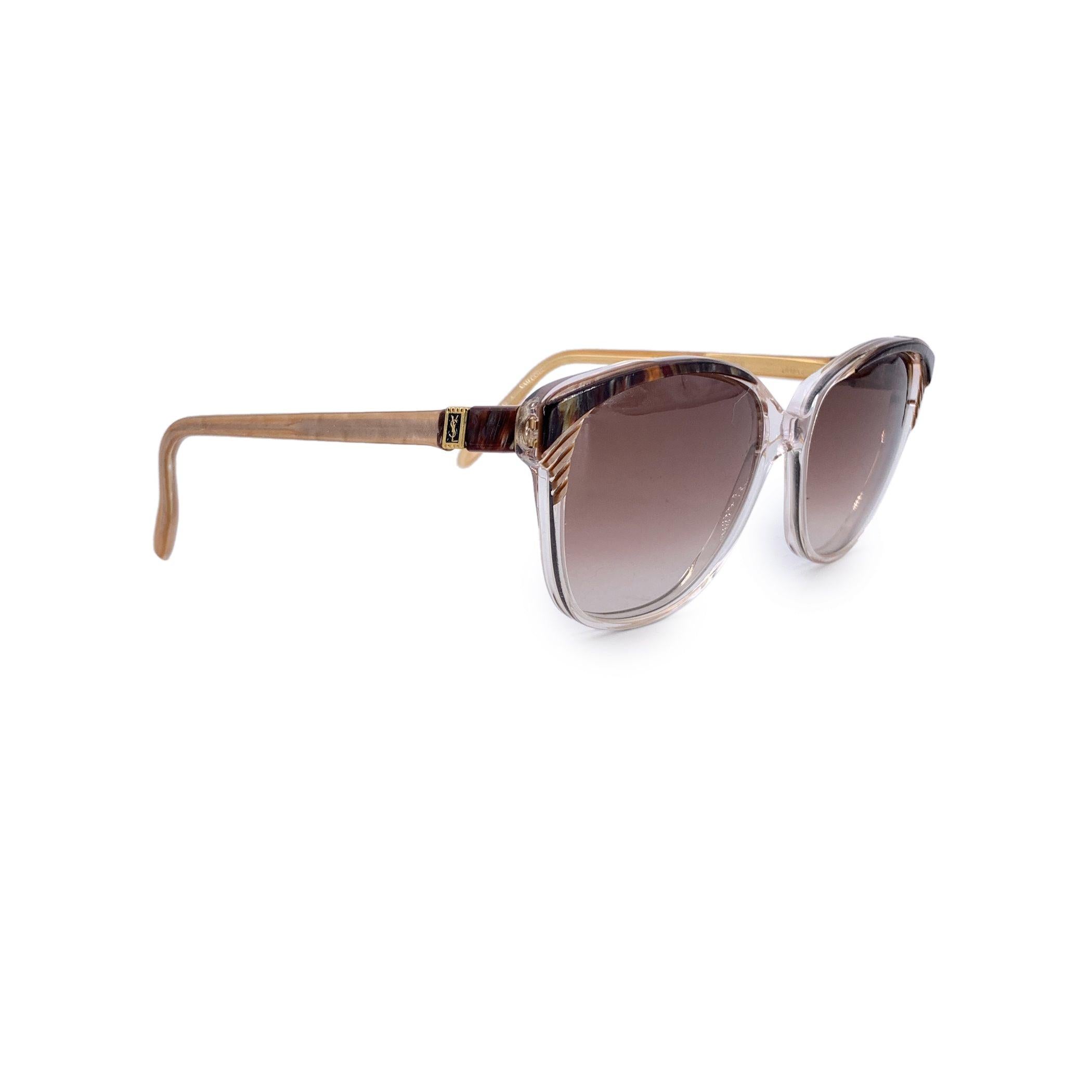 A true statement of avant-garde elegance, these vintage Yves Saint Laurent sunglasses, model SOPHOCLE, are a rare find from the golden age of French couture eyewear. Handcrafted in France, the clear acetate frame is elevated by brown marbled accents