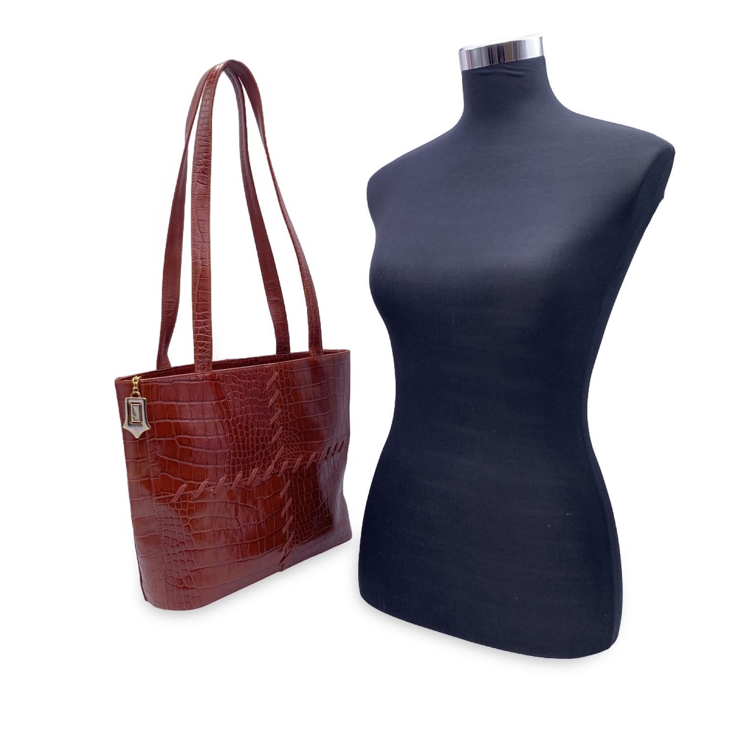 Vintage YVES SAINT LAURENT brown embossed leather tote bag. Brown whipstitch detailing Open top with middle zip section. Brown fabric lining. 'Yves Saint Laurent' tag inside.

Details

MATERIAL: Leather

COLOR: Brown

MODEL: -

GENDER: