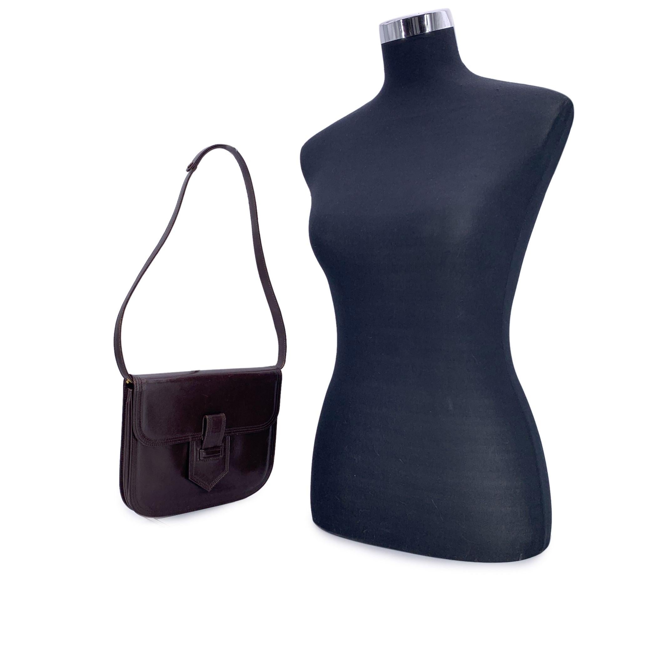 Diese zeitlose und vielseitige Umhängetasche von Yves Saint Laurent aus braunem Leder ist ein wunderschönes Stück aus einer Zeit, in der Eleganz auf Alltagstauglichkeit traf. Die strukturierte Silhouette verfügt über eine Klappe mit Knopfverschluss,