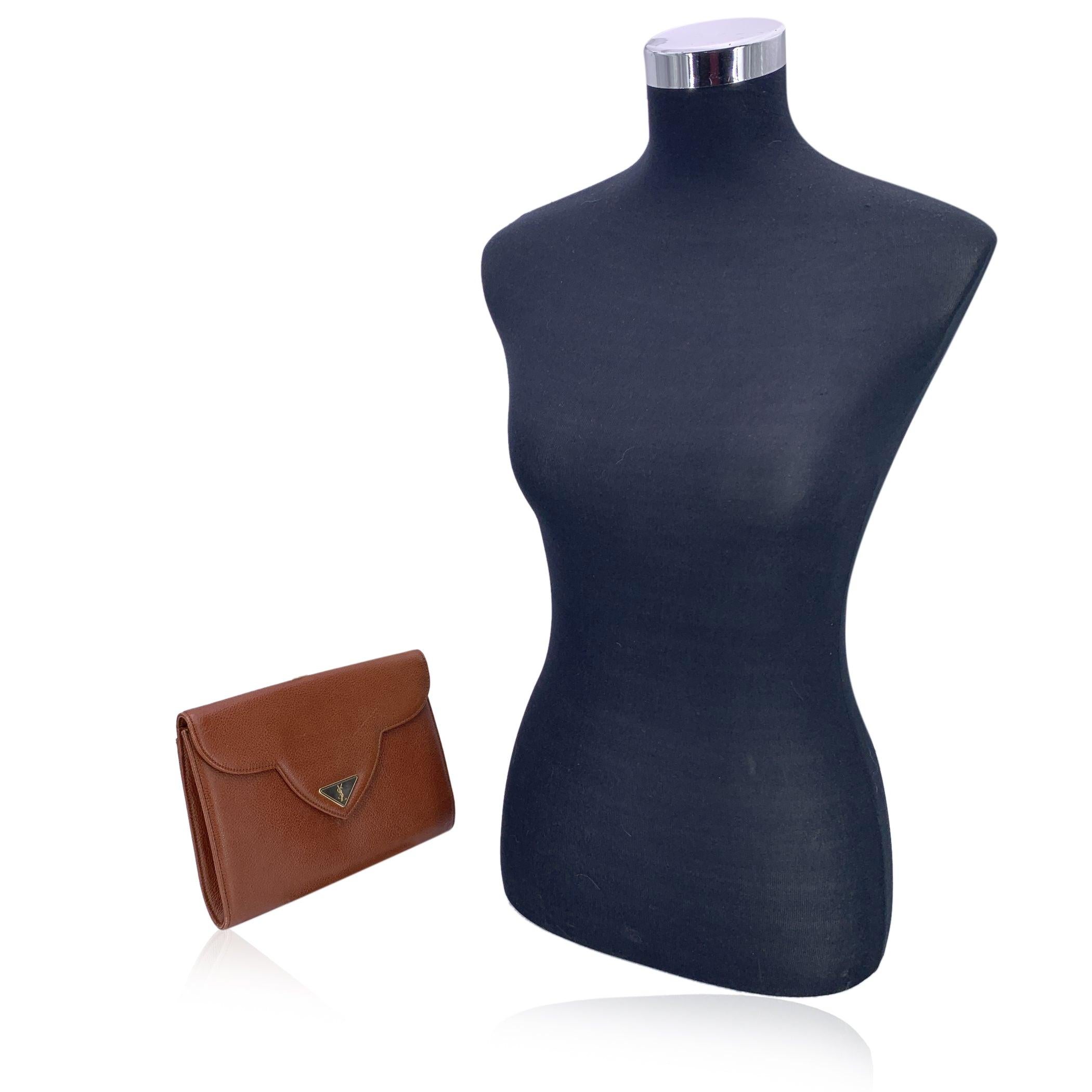 Diese Vintage-Clutch von Yves Saint Laurent ist eine atemberaubende Verkörperung von zeitloser Eleganz und raffiniertem Luxus. Die aus braunem Leder gefertigte Tasche strahlt eine klassische Raffinesse aus, die nie aus der Mode kommt. Die schlanke