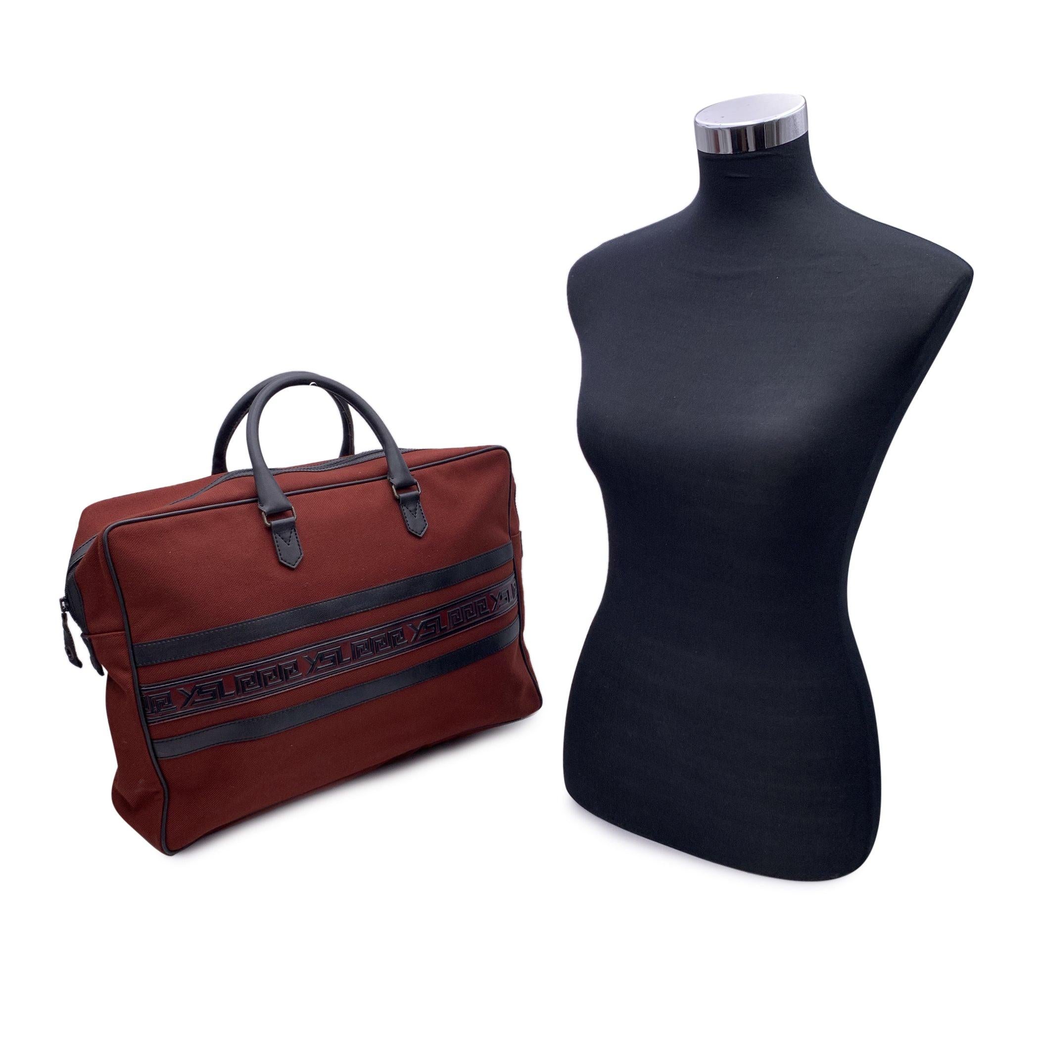Vintage Yves Saint Laurent travel bag weekened crafted in burgundy canvas with black leather trim. Logo detailing on the front and on the back. Upper zipper closure. Fabric lining. 1 side zip pocket inside. 'YVES SAINT LAURENT Paris - Made in