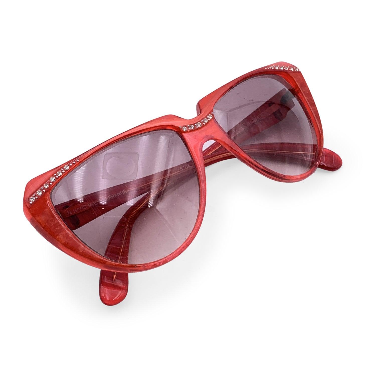 Cat-eye vintage sunglasses by YVES SAINT LAURENT from the 80s, Mod. 8704 P 74. Red frame embellished with small rhinestones on the nose bridge amd on corners. Hand-Made in France. YSL logos on the side. New 100% UV protection gradient lenses.