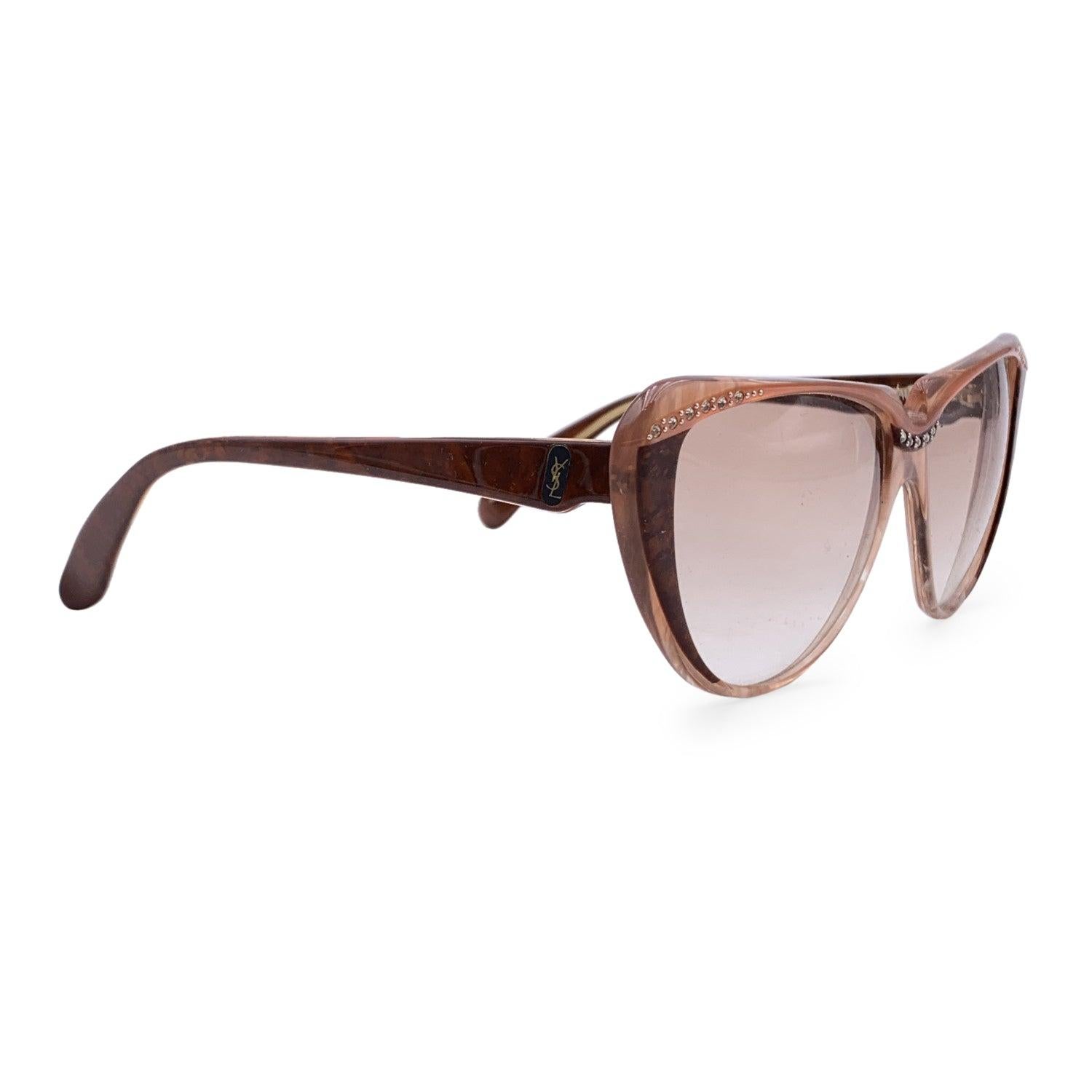 Cat-eye vintage sunglasses by YVES SAINT LAURENT from the 80s, Mod. 8704 PO 74. Brown frame embellished with small rhinestones on the nose bridge and on corners. Hand-Made in France. YSL logos on the side. New 100% UV protection brown gradient