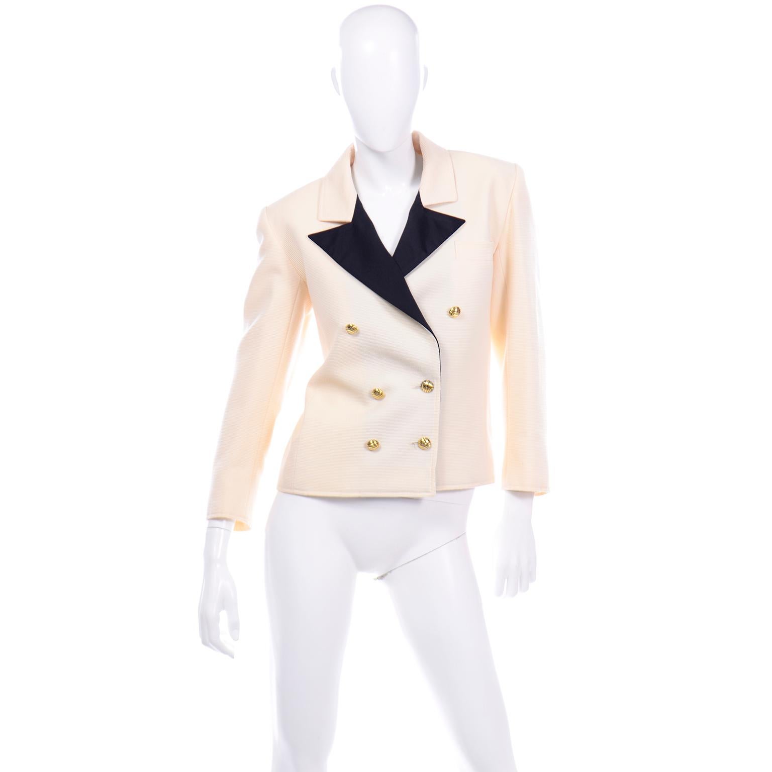 This fabulous vintage Yves Saint Laurent double breasted ribbed wool blazer jacket is in a beautiful cream color with black satin silk lapels. There are nice, heavy gold tone metal ribbed buttons in the front and on the sleeves. The shoulders are