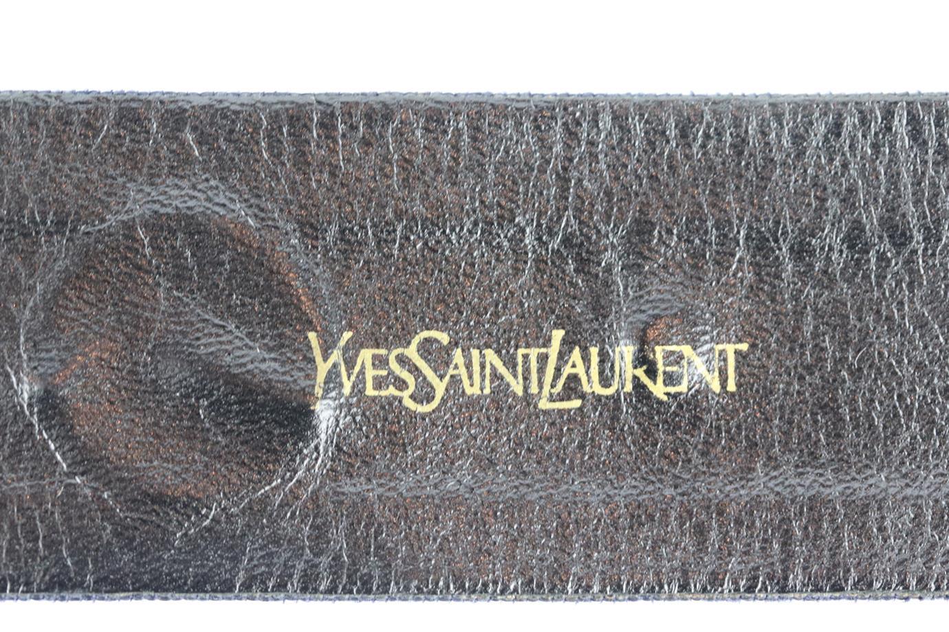 Yves Saint Laurent Vintage embellished grosgrain waist belt. Made from navy grosgrain with gold-tone suns. Navy. Buckle fastening at front. Min Length: 26 in. Max Length: 28 in. Width: 1.6 in